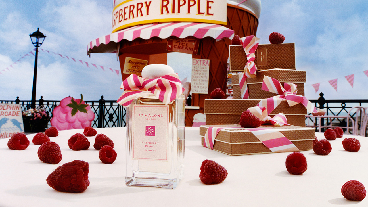 Jo Malone Raspberry Ripple cologne with a pier background, surround by raspberries