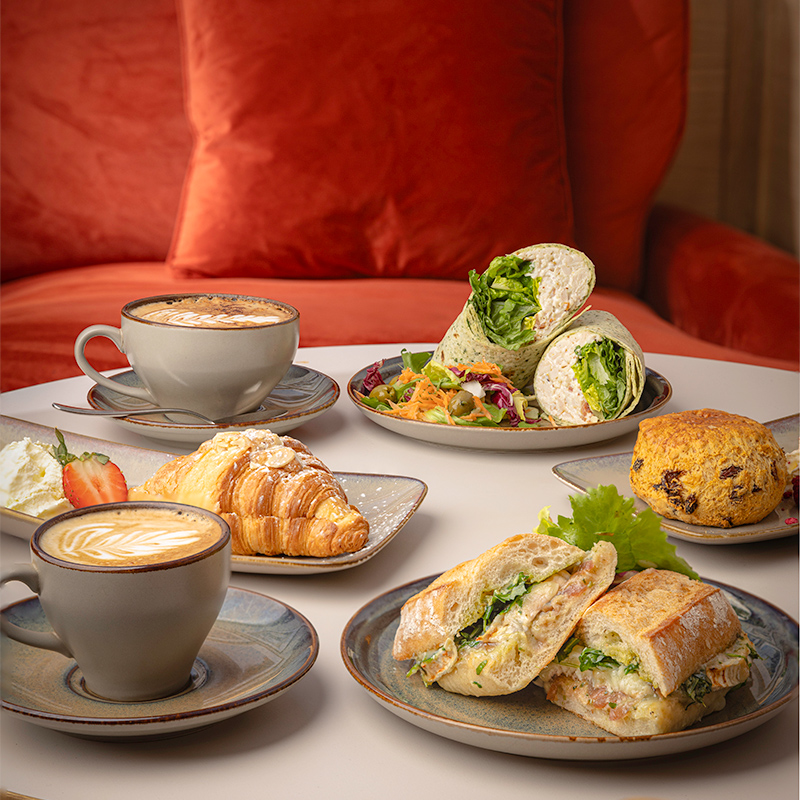 A stack of grilled sandwiches filled with various ingredients on a wooden board.