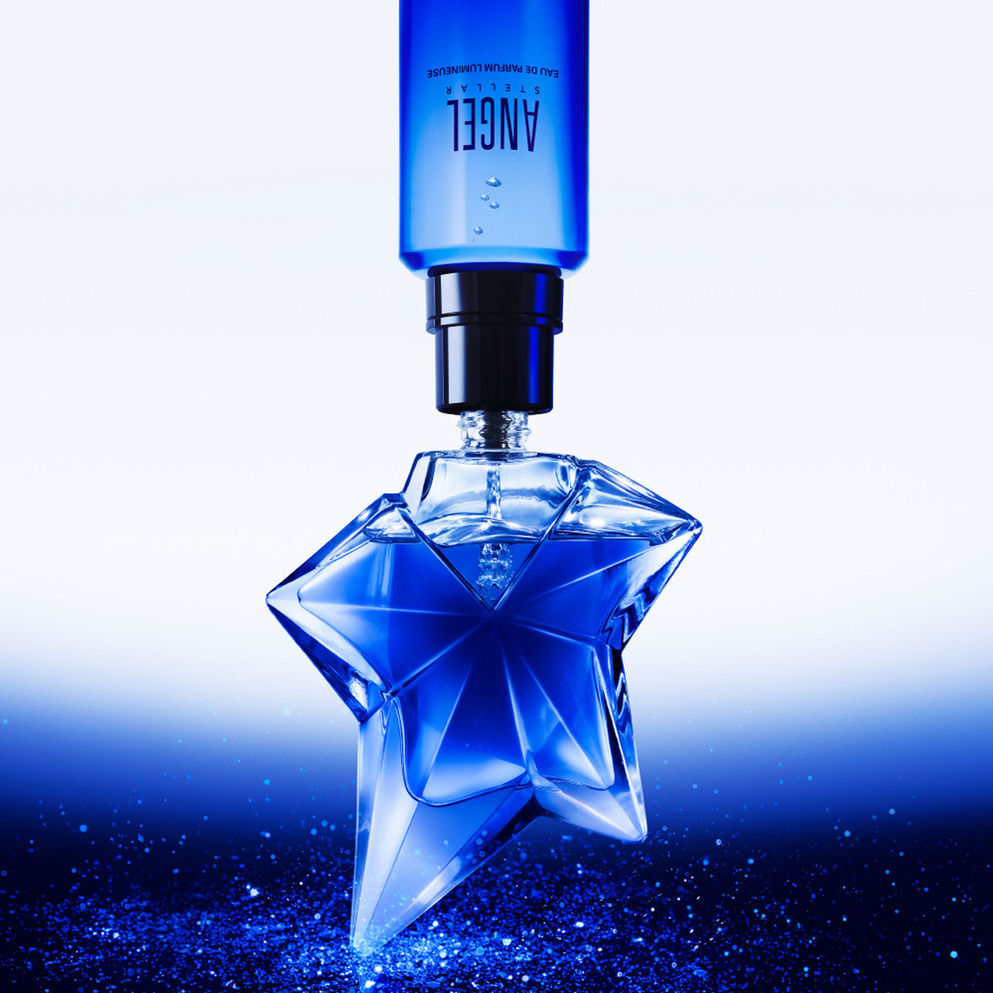 MUGLER Angel Stellar Eau de Parfum 100ml, iconic star-shaped blue glass bottle with refill bottle above, on glittering blue background