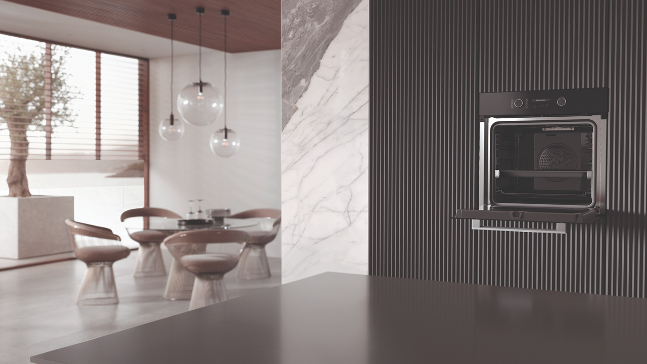 Modern kitchen with a Miele oven, featuring sleek marble and wood elements, and a dining area with stylish chairs and pendant lights.