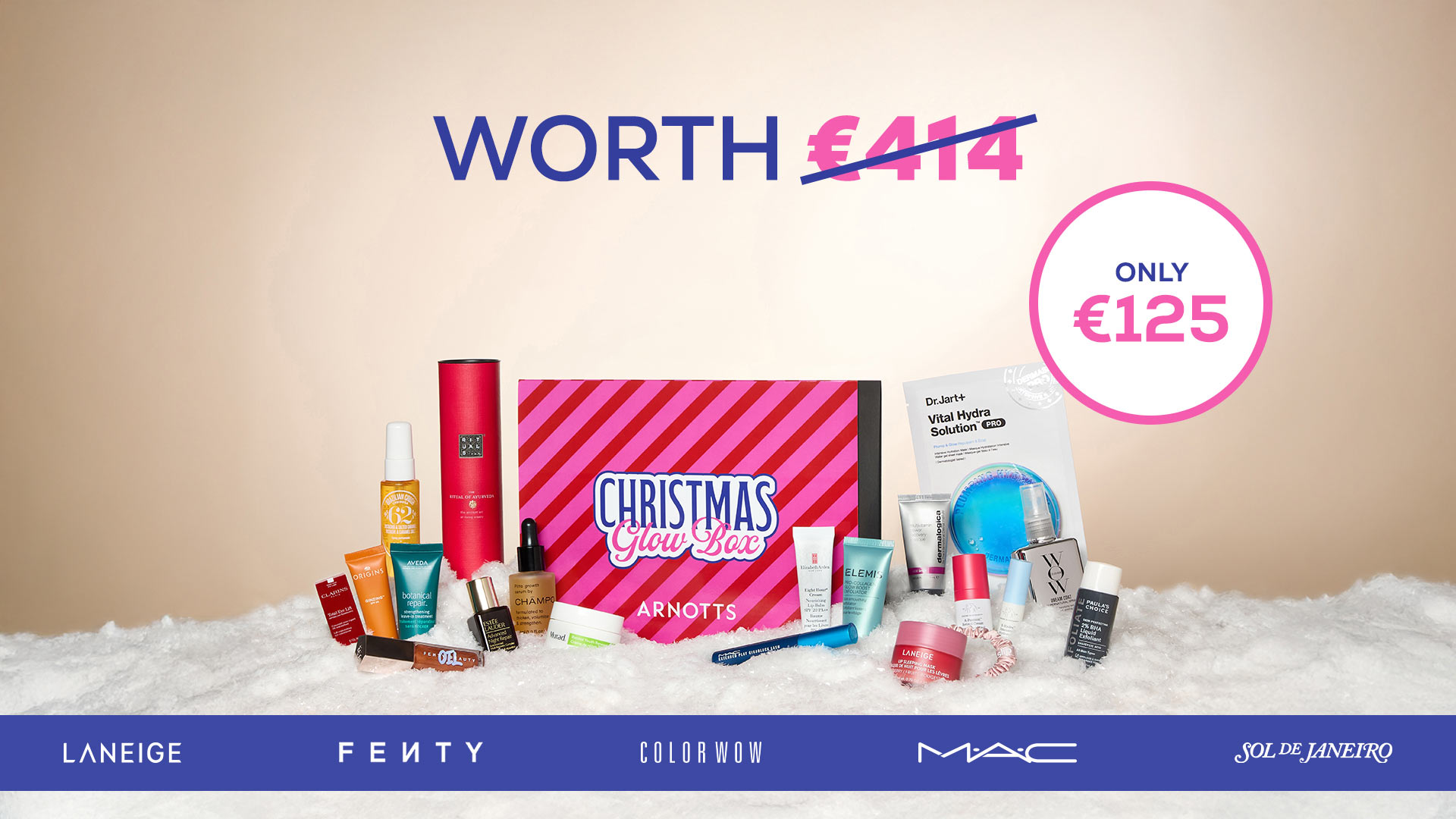 A variety of beauty products are displayed around a 'Christmas Glow Box' valued at €414, now priced at €125. Brands include Laneige, Fenty, and MAC.