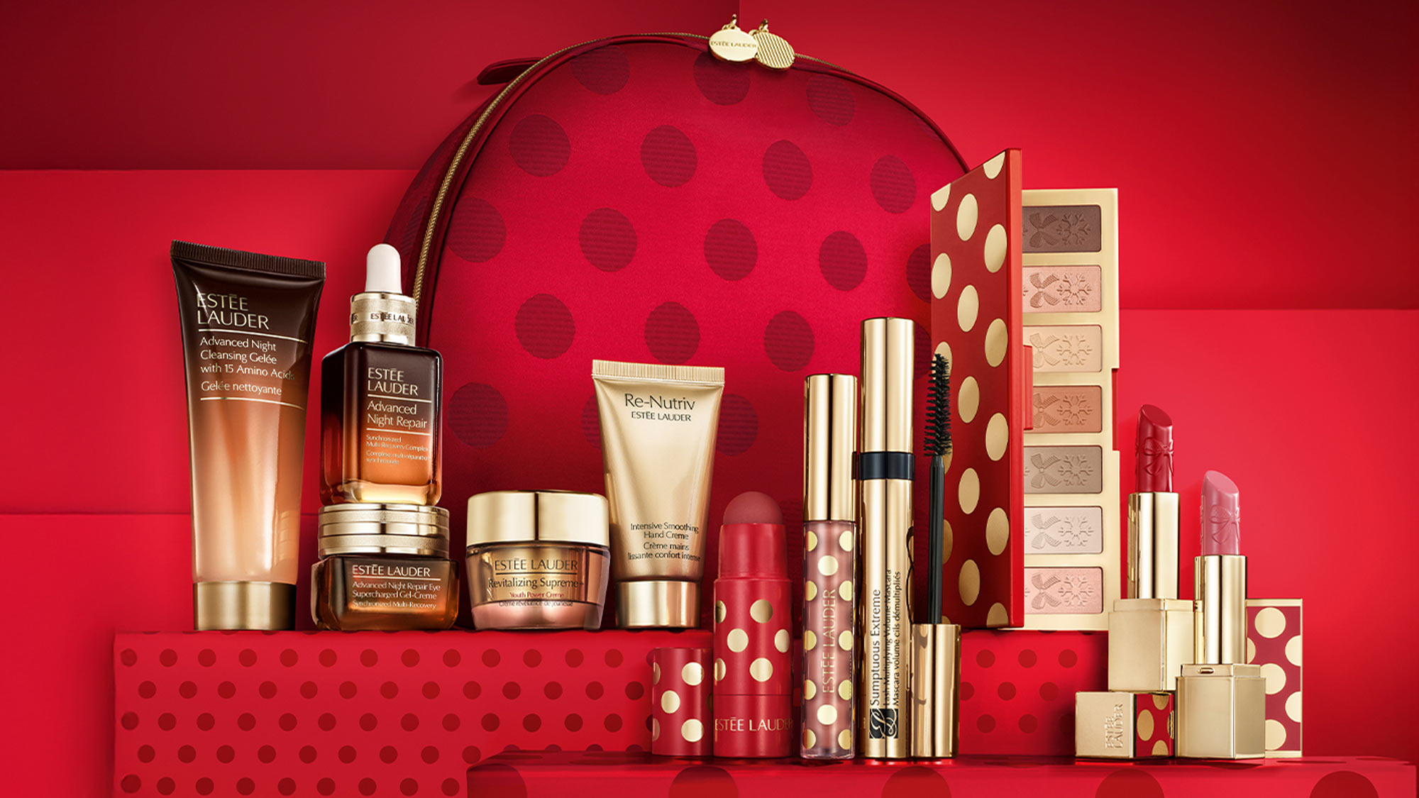 A red-themed makeup and skincare set, including creams, lipsticks, and an eyeshadow palette, displayed with a matching patterned bag.