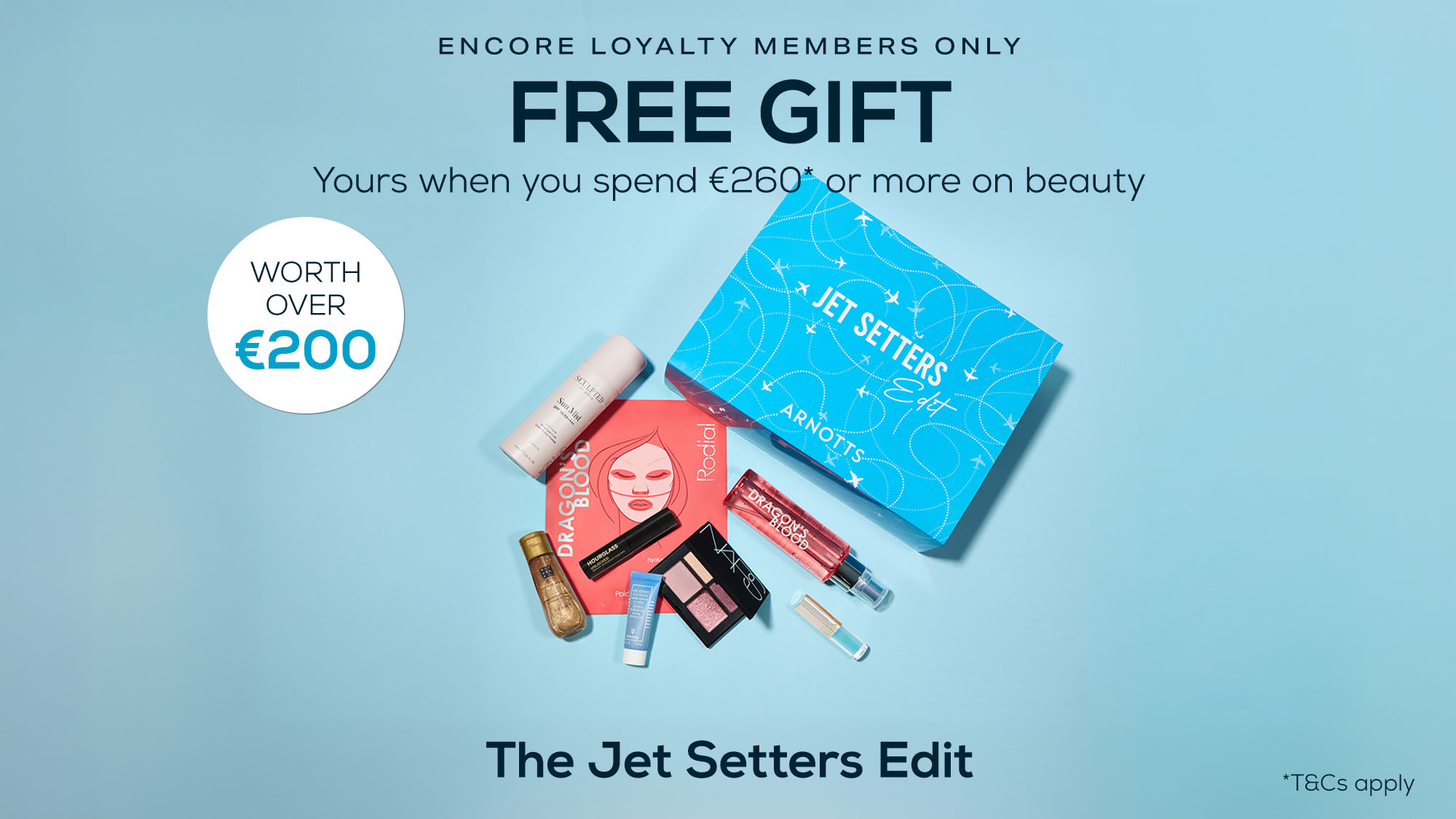 Blue background with text promoting a free gift for spending €260+ on beauty. Showcases beauty products and a blue 'Jet Setters Edit' box.