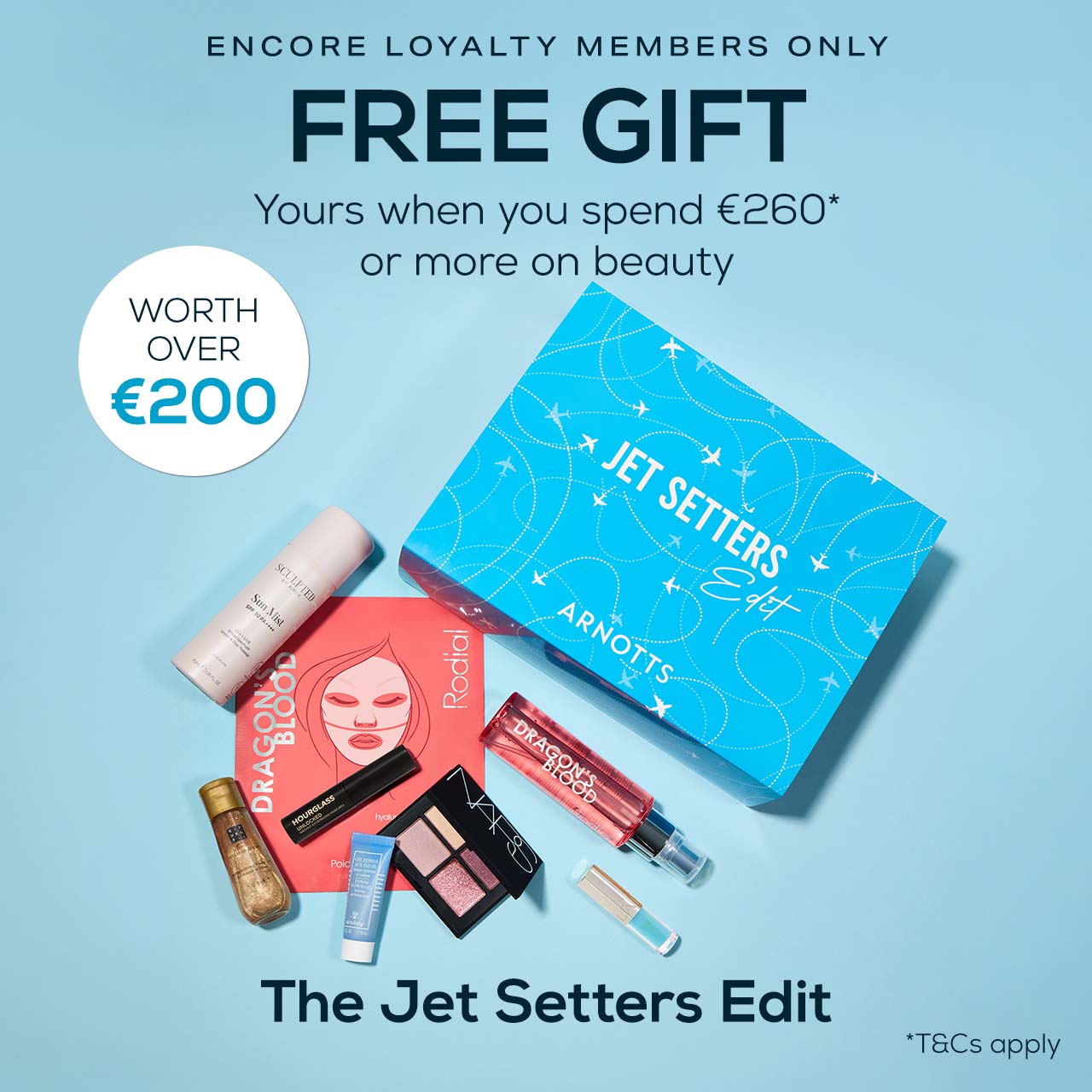 Blue background with text promoting a free gift for spending €260+ on beauty. Showcases beauty products and a blue 'Jet Setters Edit' box.