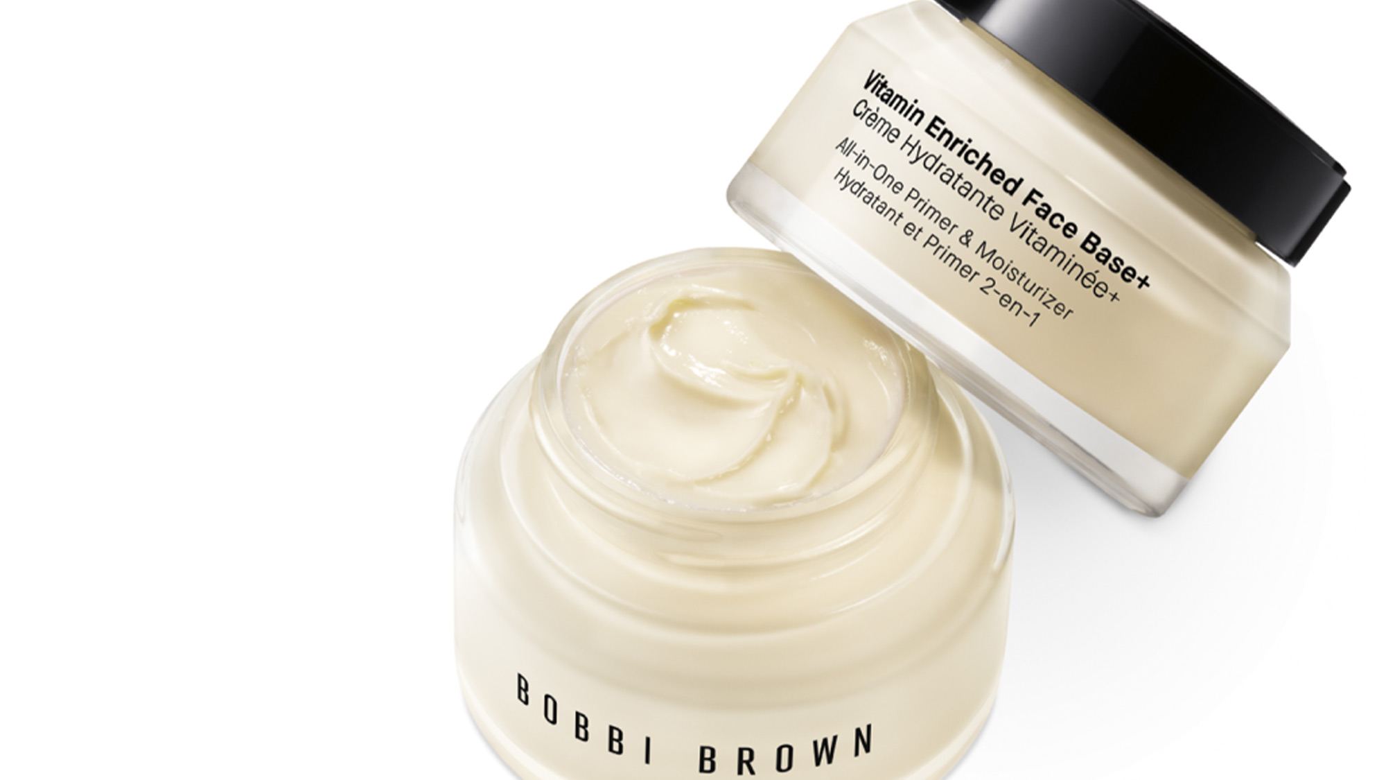 Vitamin Enriched Face Base+ cream in white jar with black cap, showing texture and product label describing all-in-one primer with vitamins