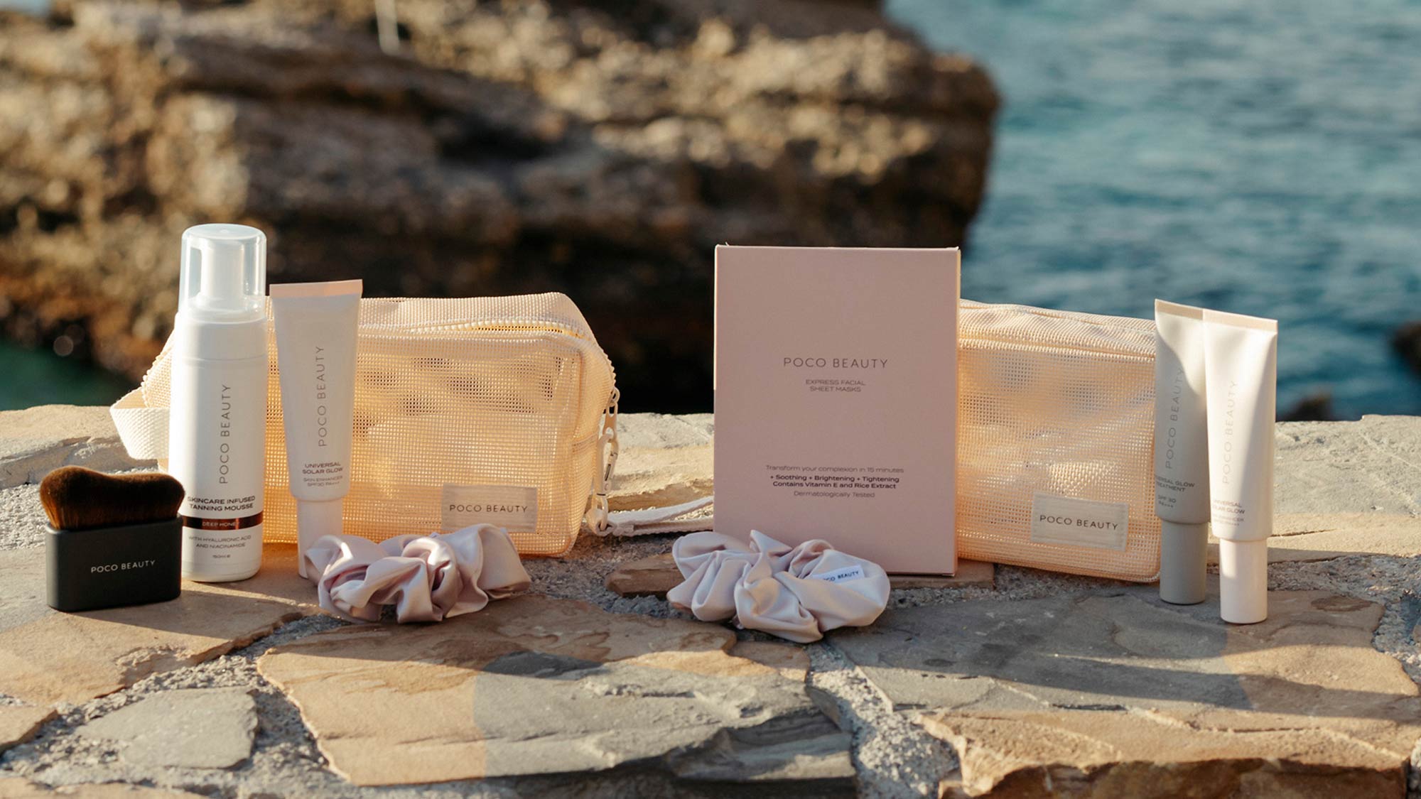 POCO Beauty Summer Edit sets displayed on coastal rocks by sea, featuring golden mesh pouches, skincare products, sheet masks and packaging