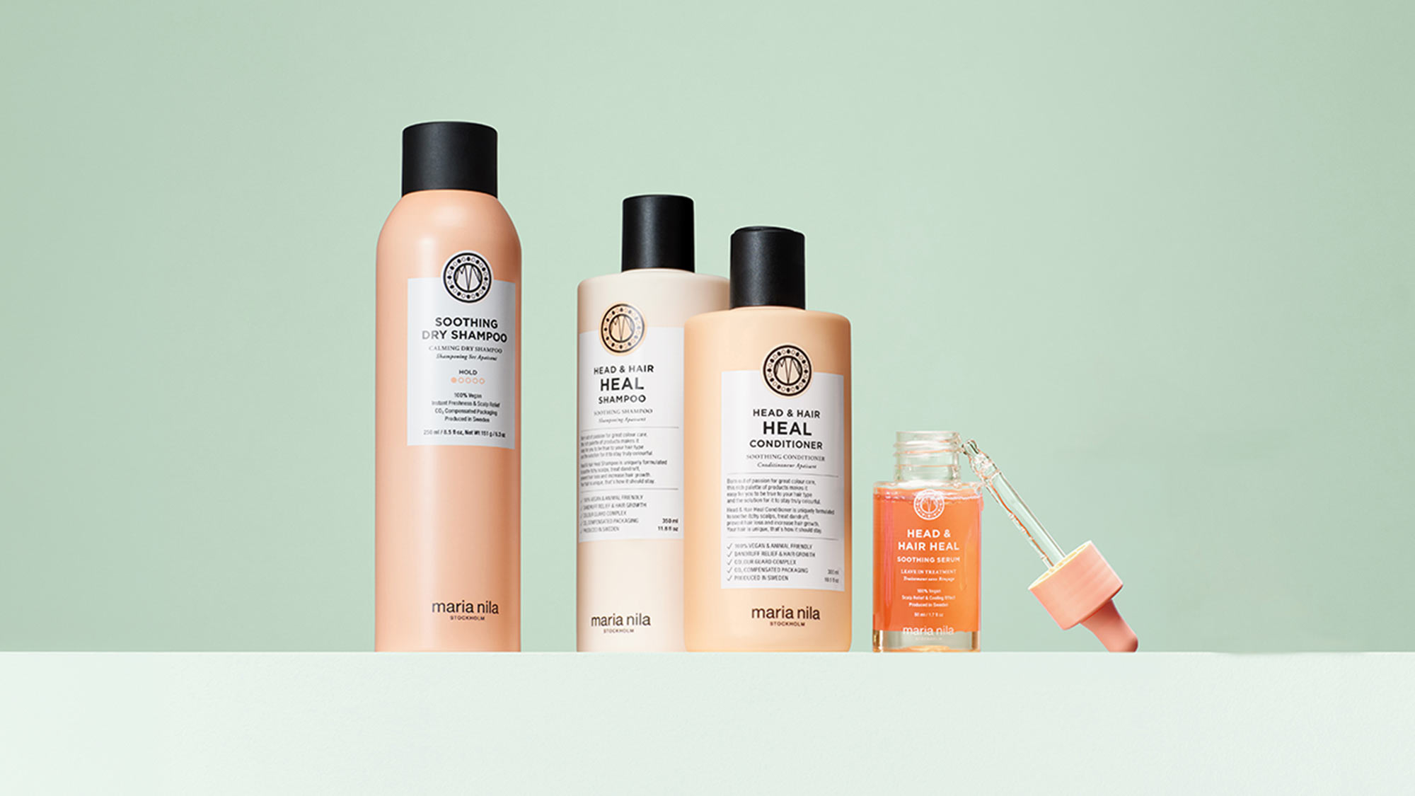 Maria Nila hair care collection including dry shampoo, healing shampoo, conditioner, and soothing serum bottles against soft green background