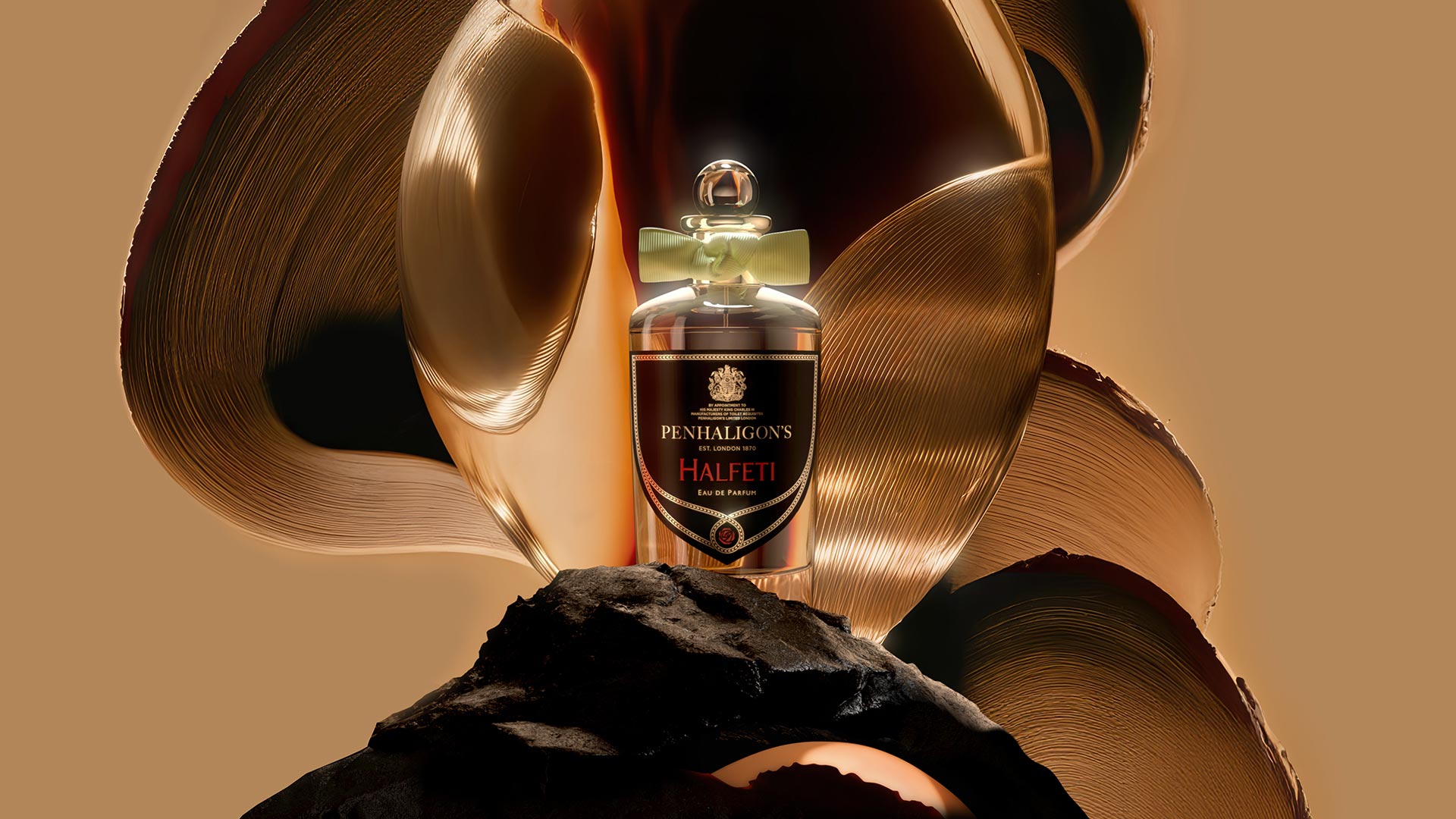Penhaligon's Halfeti eau de parfum bottle on dark stone with flowing bronze and gold metallic ribbons against neutral background