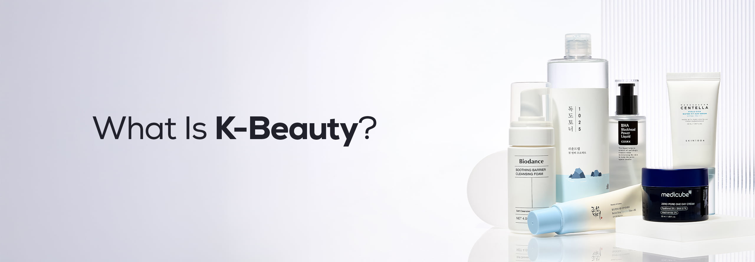 A selection of Korean skincare products is arranged around a 'K Beauty' logo on a light blue background.