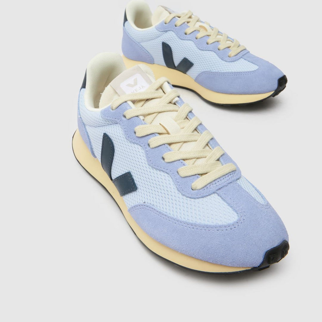 white Veja shoes over a green background