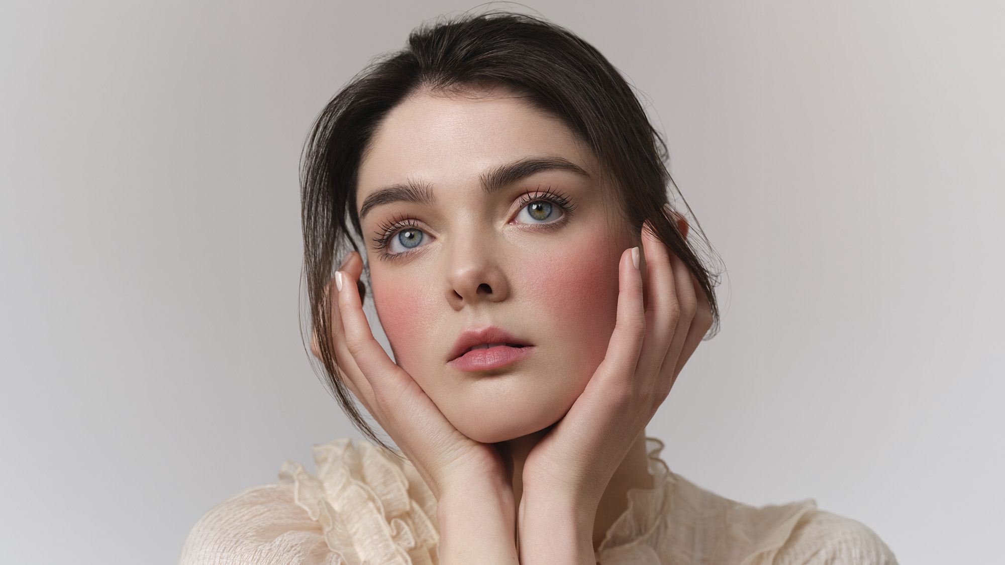Woman with flawless bridal makeup featuring glowing skin, defined eyes with bronze eyeshadow and lashes, and soft pink lips