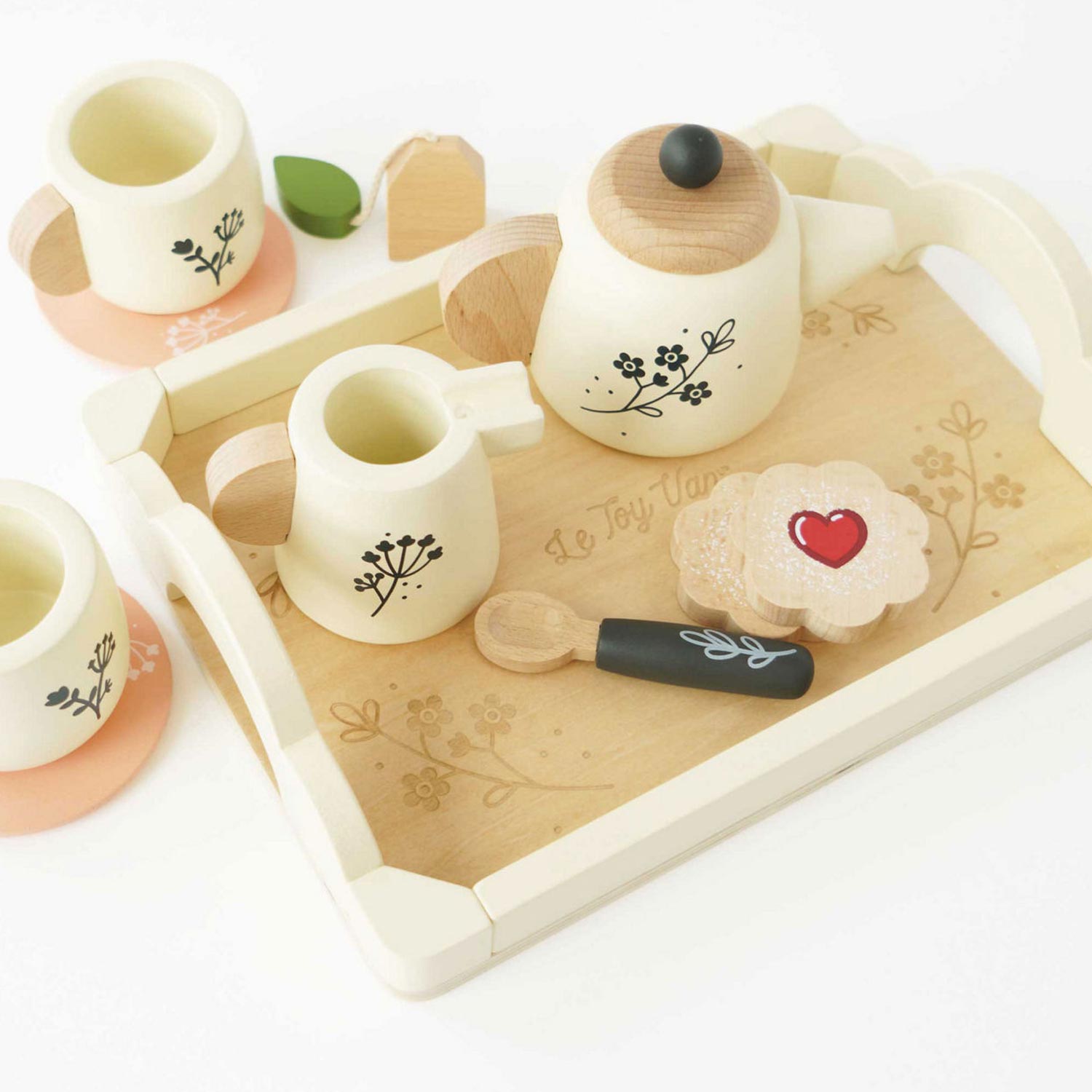 Wooden tea set and picnic props laid out on a blanket for a teddy bear's tea party celebration.