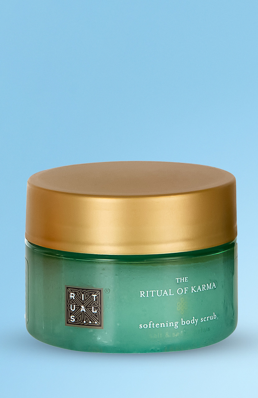 A green jar of 'The Ritual of Karma' softening body scrub with a gold lid.