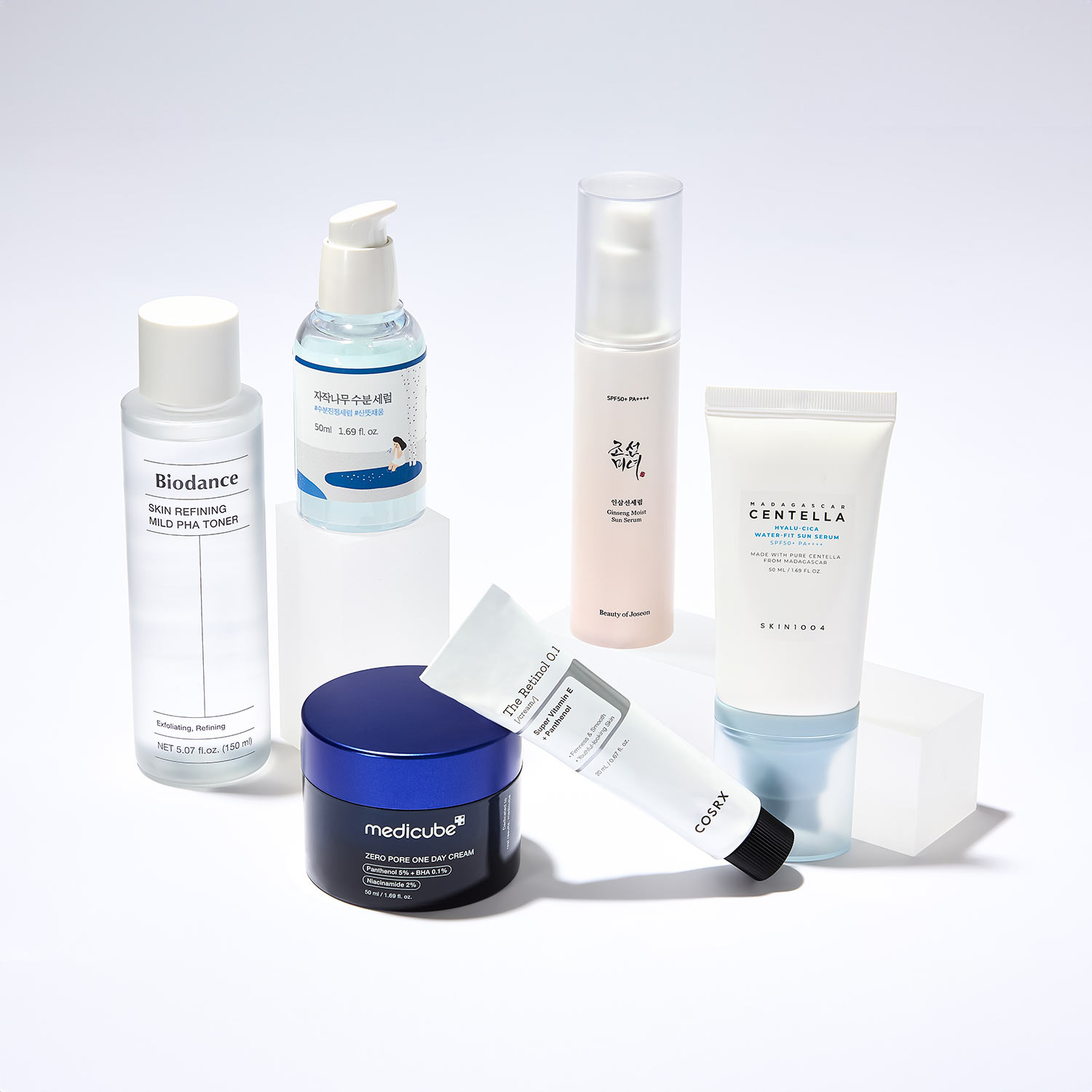 A selection of skincare products, including bottles and tubes, displayed on a white surface.