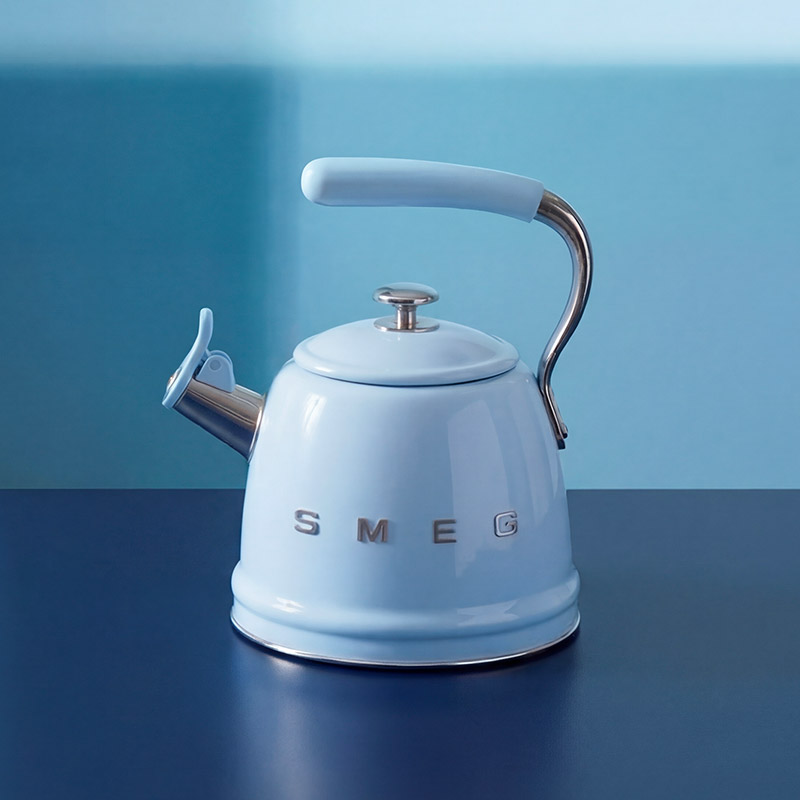 Light blue kettle with 'SMEG' branding, featuring a chrome handle and spout, on a dark blue surface against a light blue background.