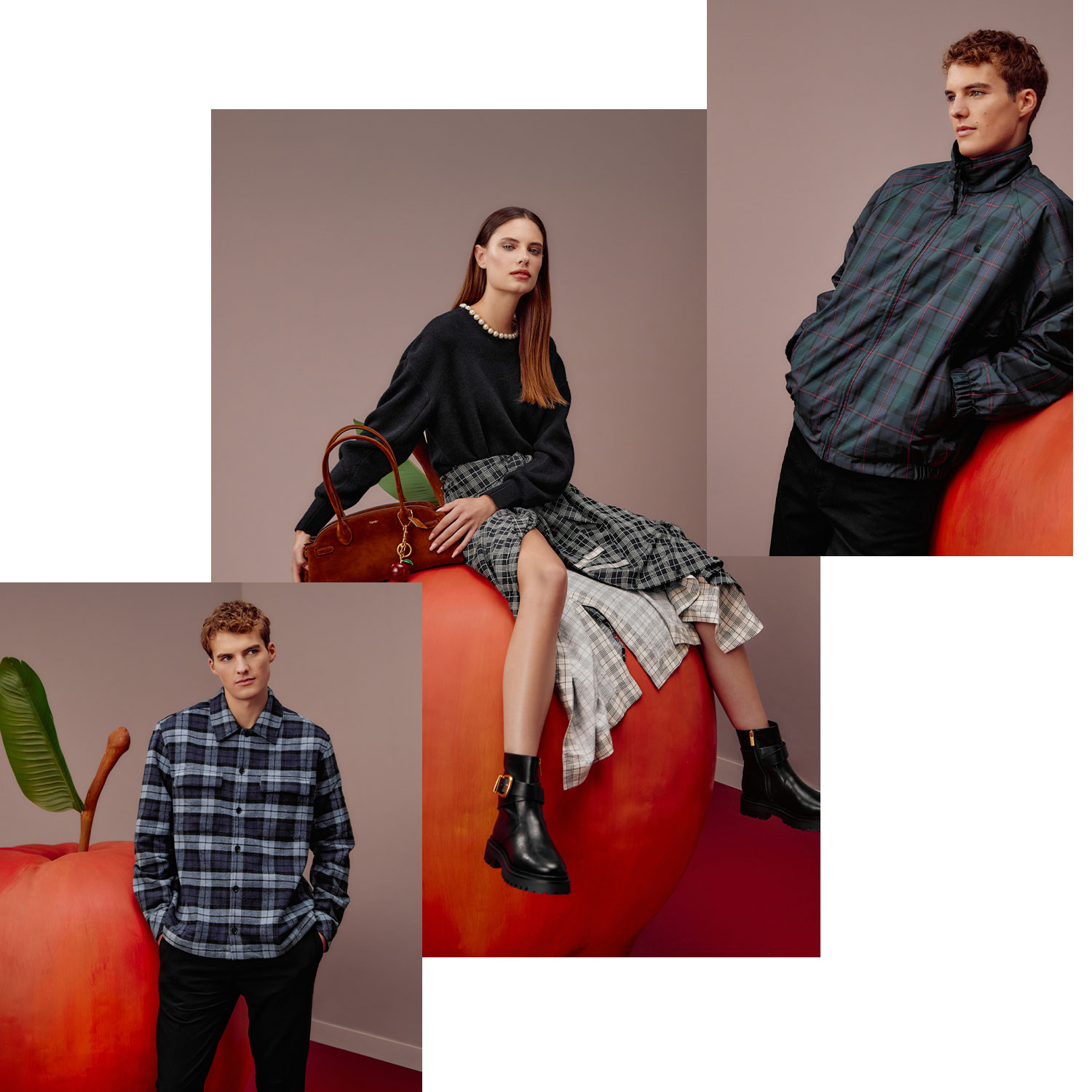 A fashion photoshoot features a man and woman in stylish clothes posing with a giant red apple.