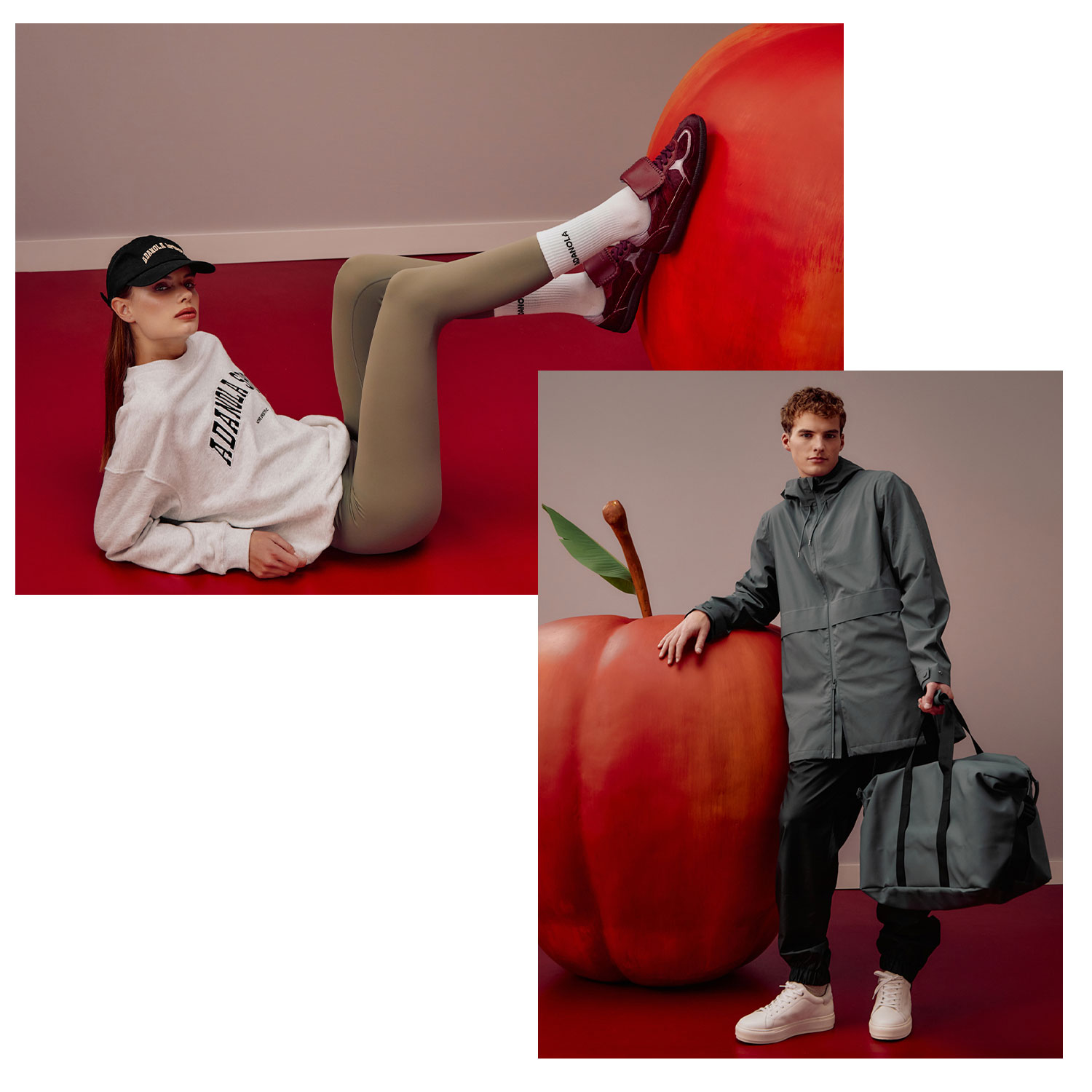 Two people in casual outfits pose with oversized red apples in a minimalist setting.