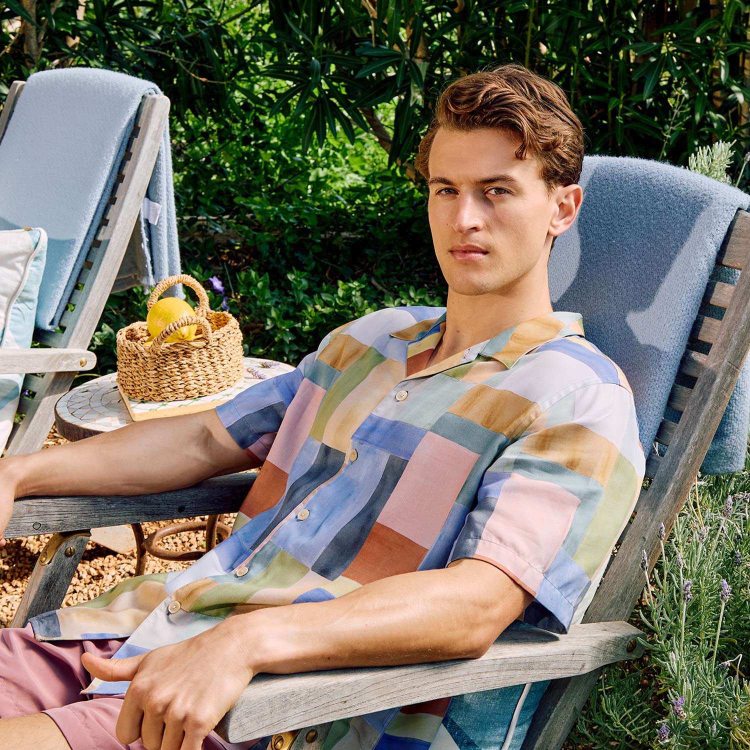 man in patterned blue shirt sitting down