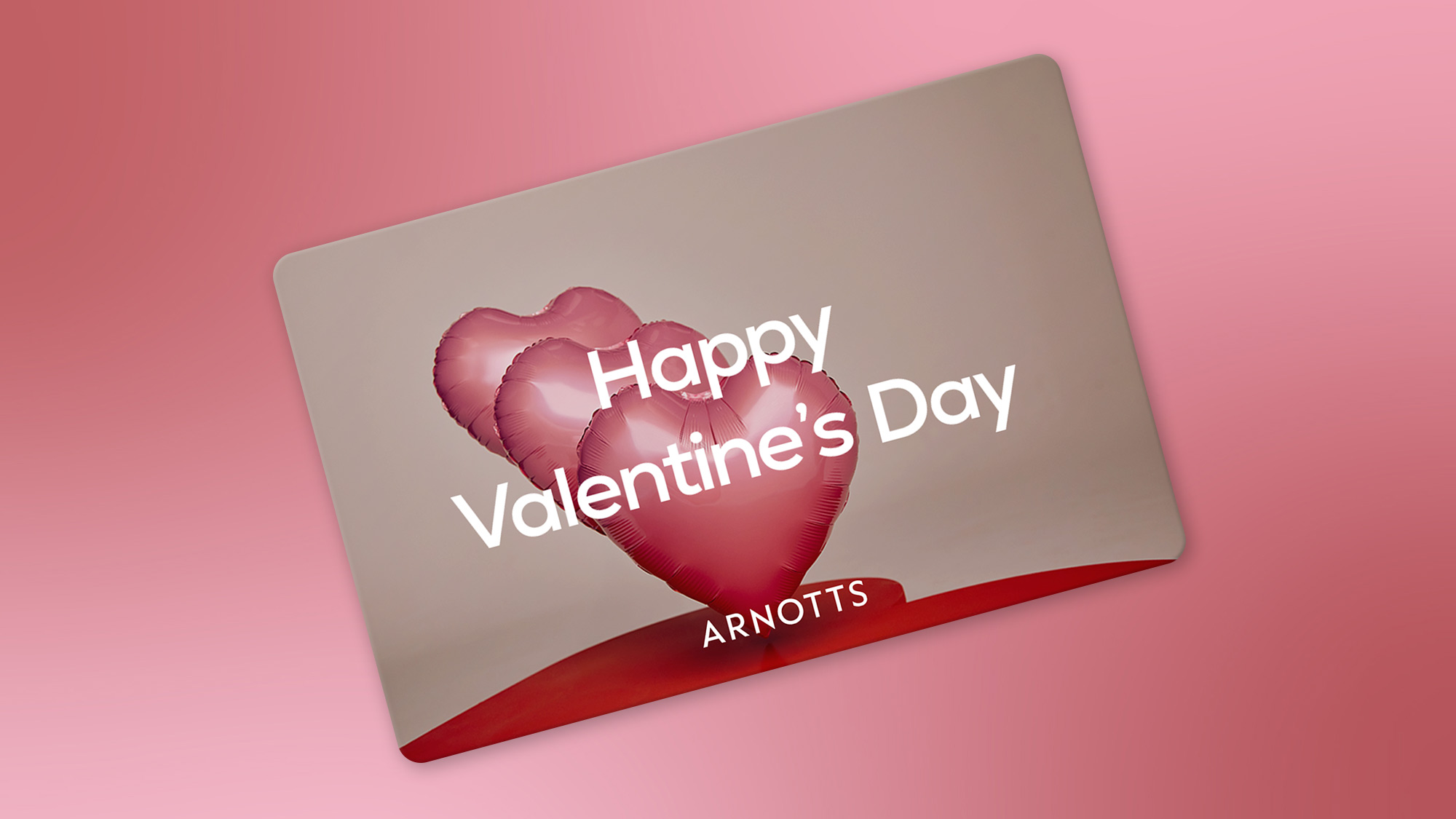 A collection of items on a red surface, including pink heart-shaped balloons, a purse, gift boxes, a face mask device, and various cosmetics.