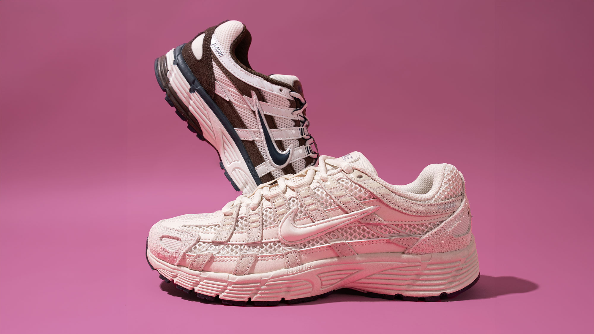 Two sneakers, one pale pink and one black and white, stacked on a pink background.