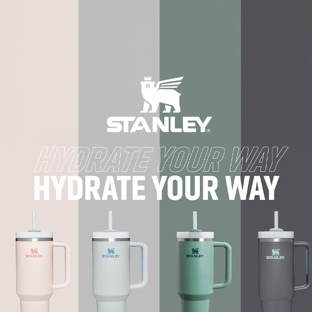 Four Stanley tumblers in pastel colors are lined up with the text 'HYDRATE YOUR WAY' above them.
