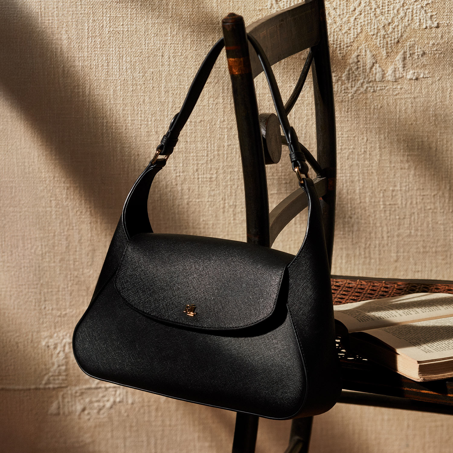 a black handbag hanging off a chair