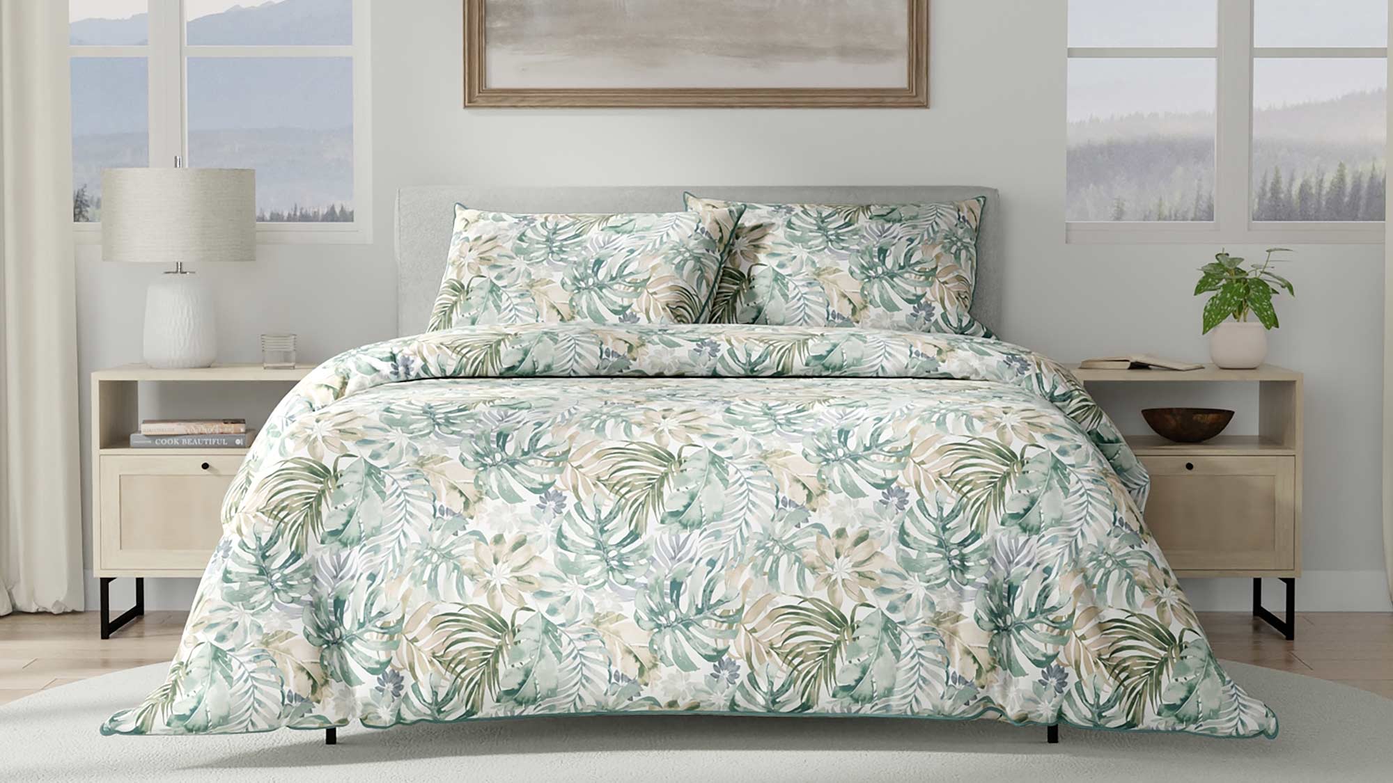 A bedroom with a floral-patterned bedspread, matching pillows, wooden nightstands, and a nature painting above the bed.