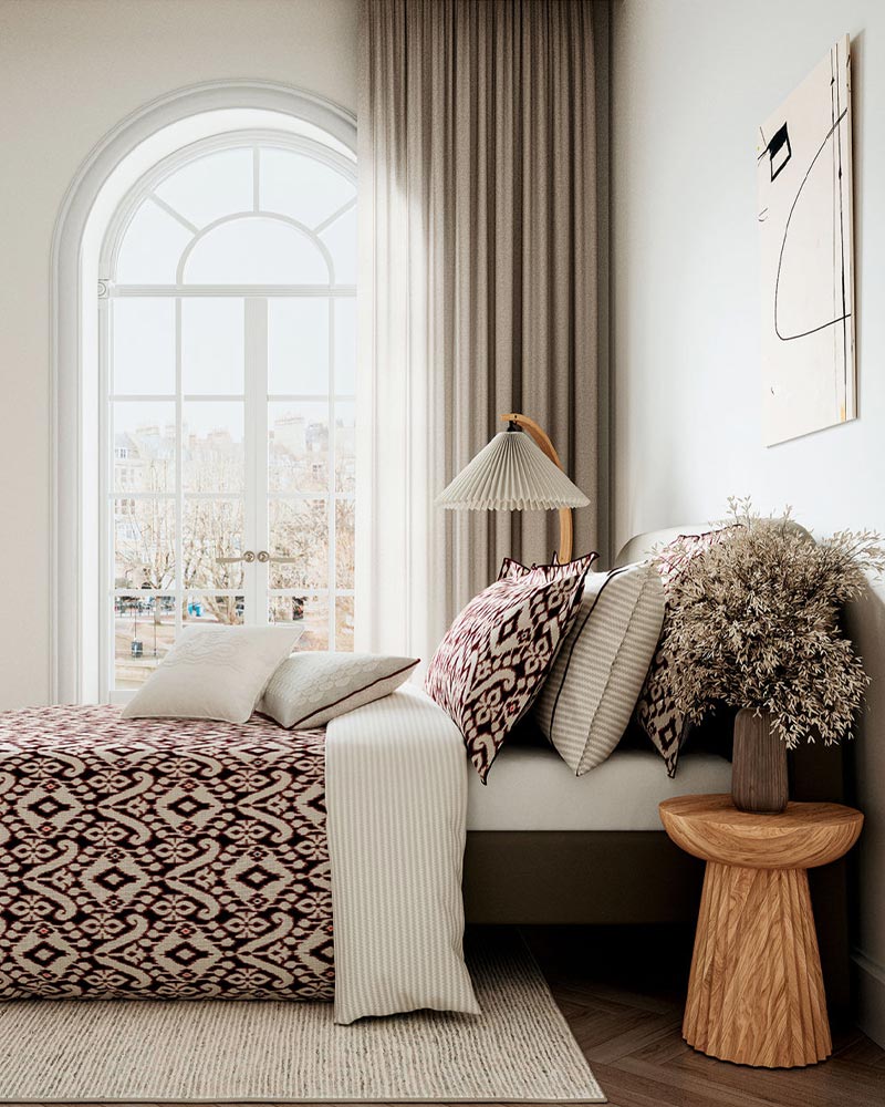 A neatly made bed with a white duvet cover featuring colorful leaf patterns.