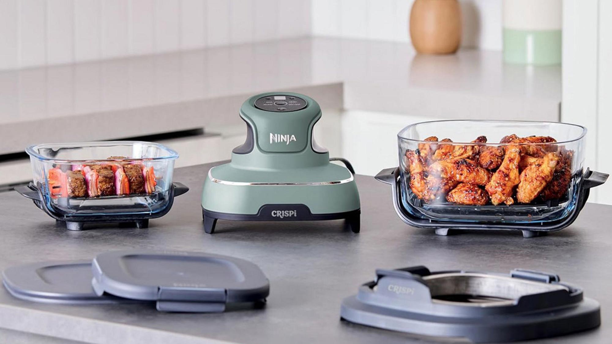 Kitchen countertop with a Ninja food processor and two glass containers with cooked meat.