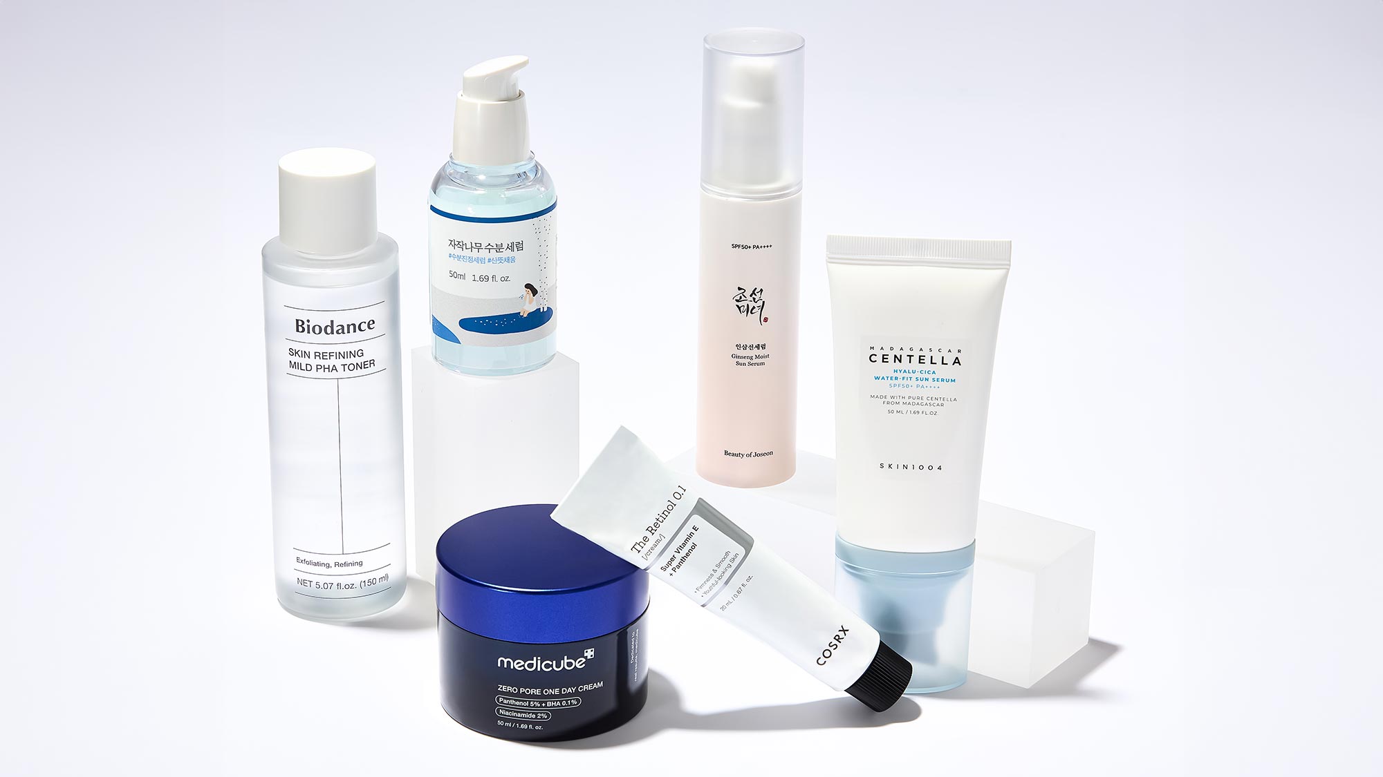 A selection of skincare products, including bottles, a jar, and a tube, arranged on a white background.