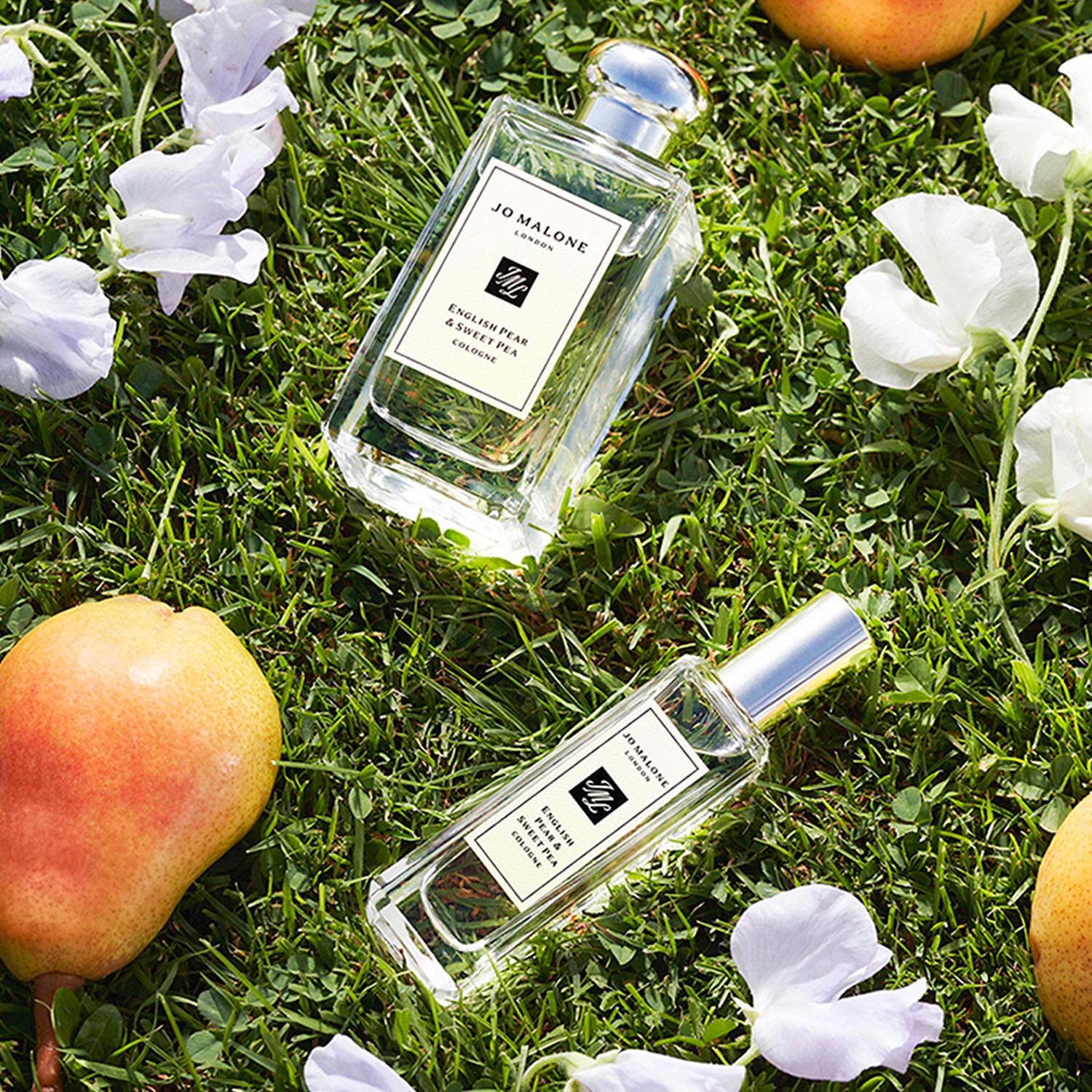 jo malone london bottles lying on grass with oranges