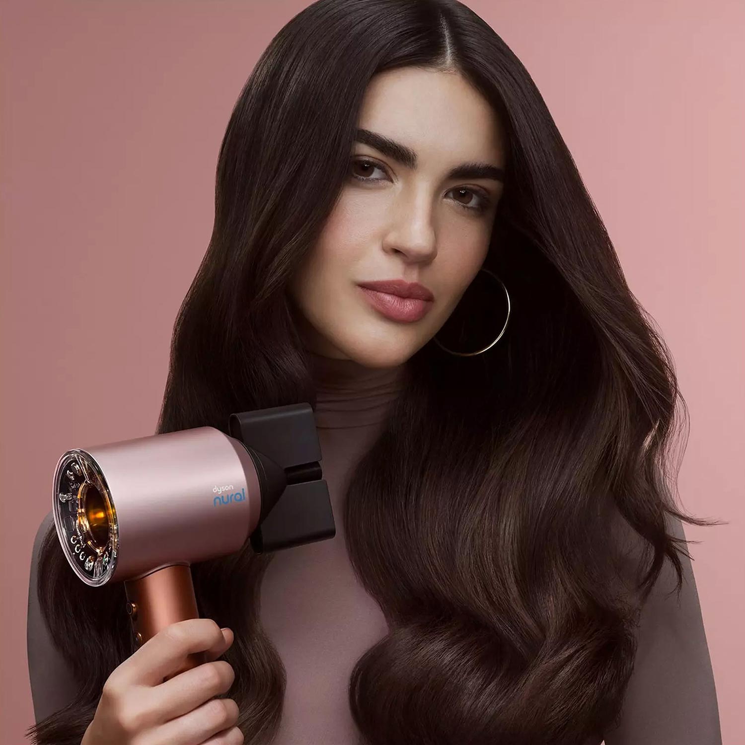 woman with hair done holds a dyson nural electrical tool