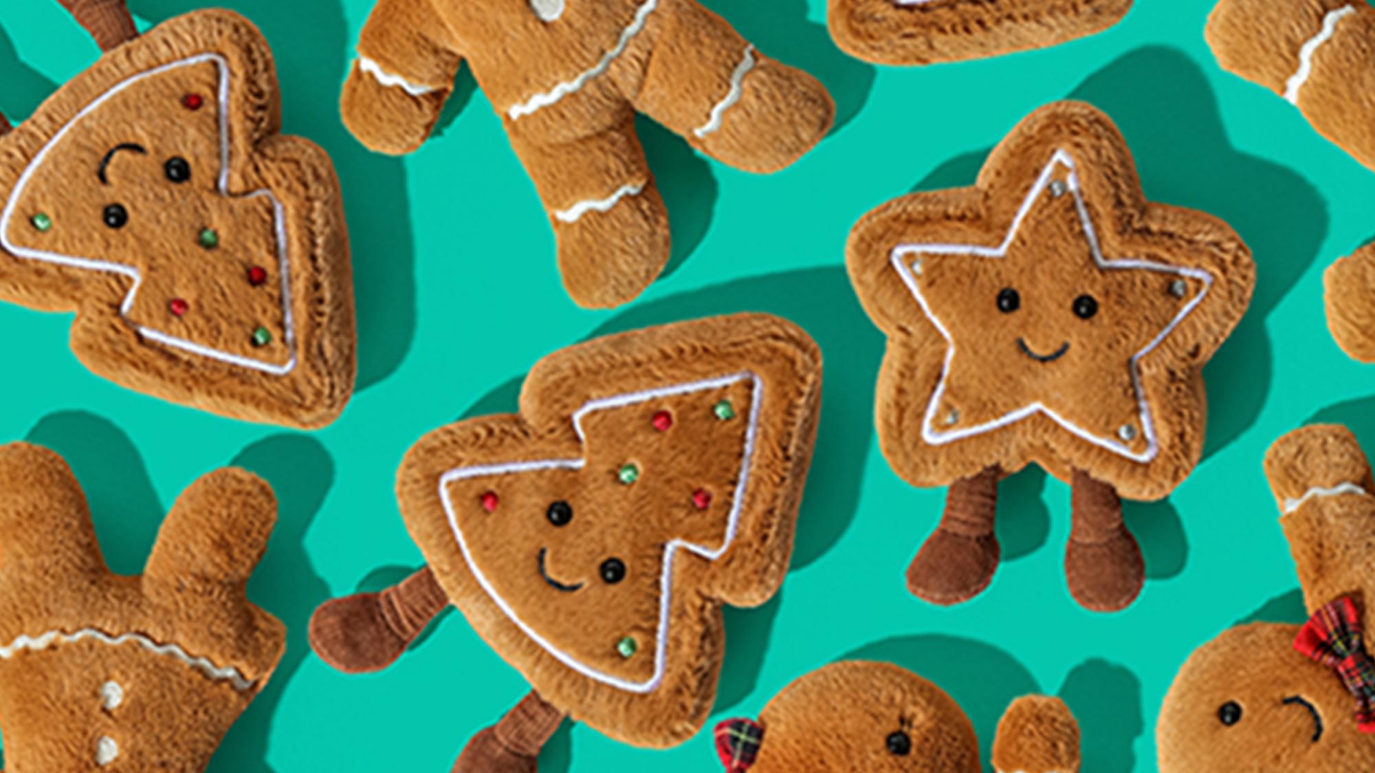 Pattern of gingerbread men and tree cookies with icing and bows on a turquoise background.