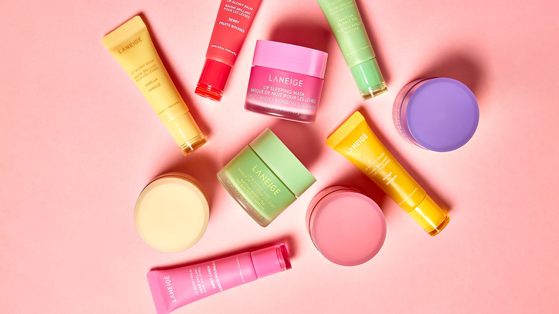 Various colorful Laneige skincare products arranged on a pink background.