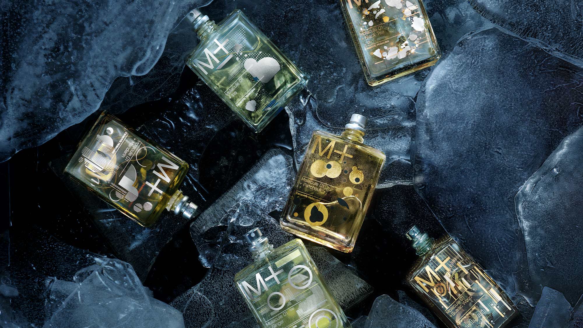 Six perfume bottles with '+ M' labels, arranged among large ice cubes.