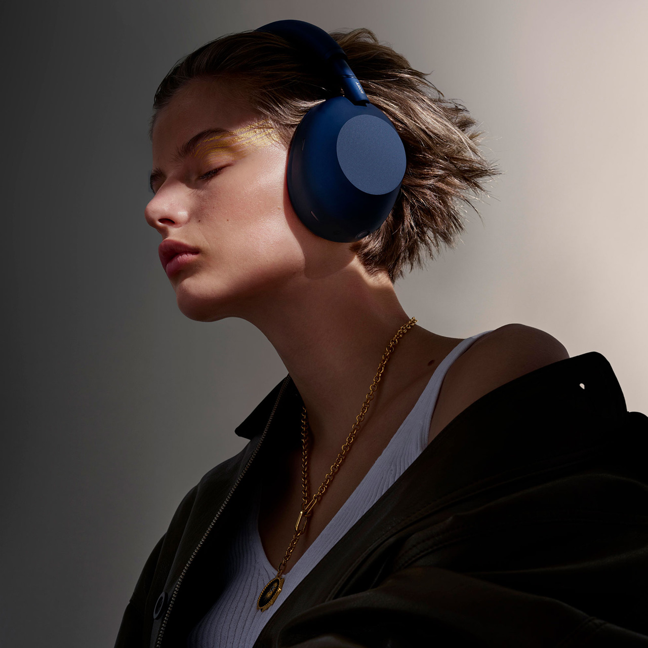 A woman wears headphones and a red sun visor.