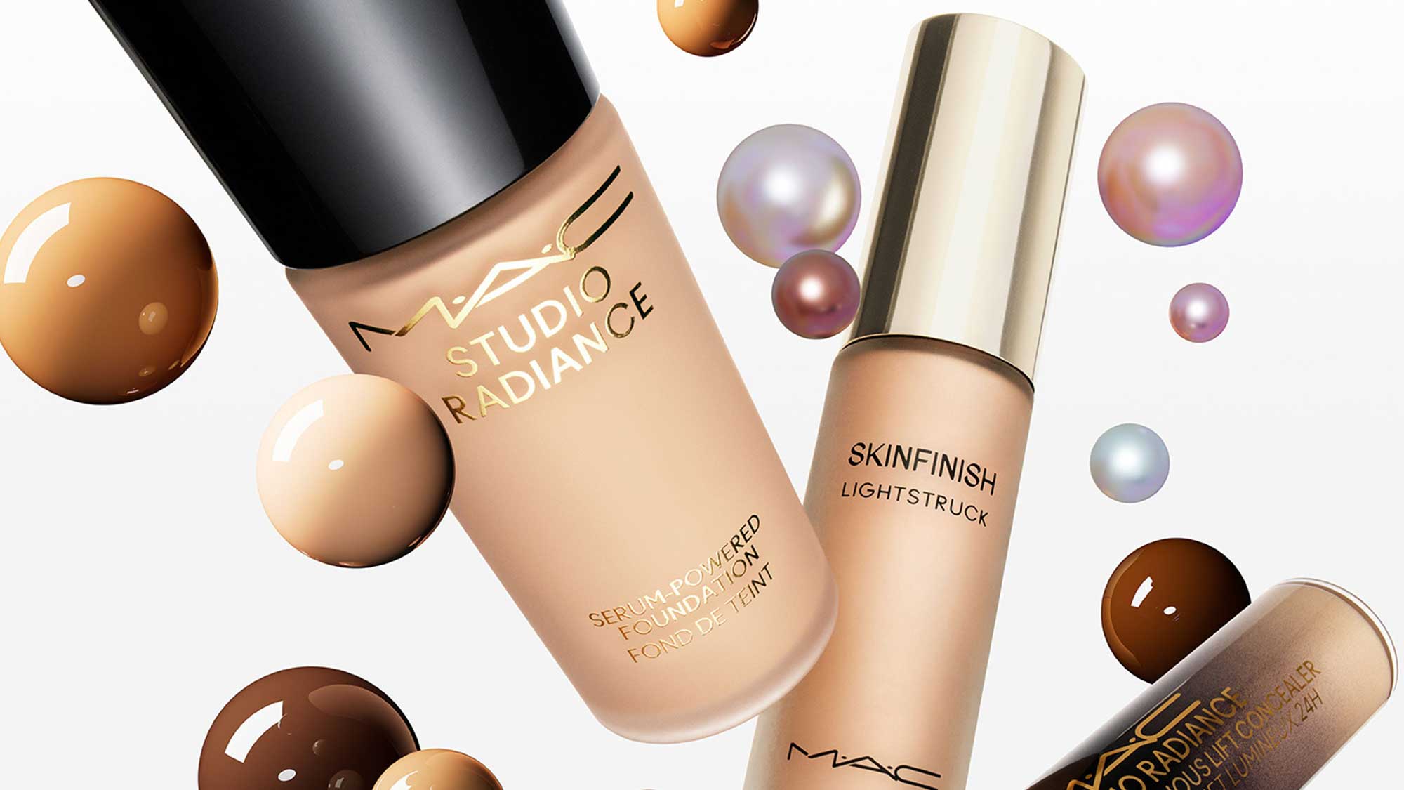 Three MAC cosmetics products with foundation droplets in various shades on a white background.