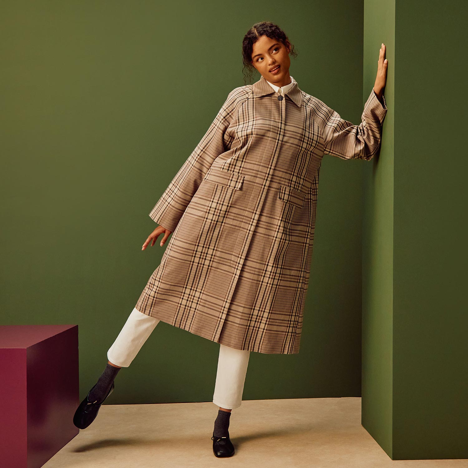 Woman wearing beige check shirt dress with white leggings and black ankle boots