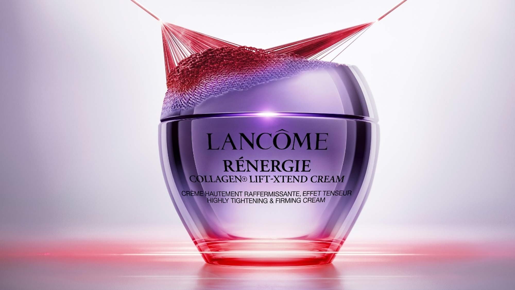 A collection of Lancôme skincare products is displayed in front of a pink-striped bag on a white platform labeled 'Exclusive to Arnotts.'