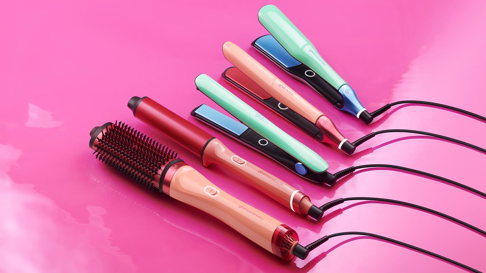 Colourful GHD hair styling tools in candy-inspired pastel shades against pink background