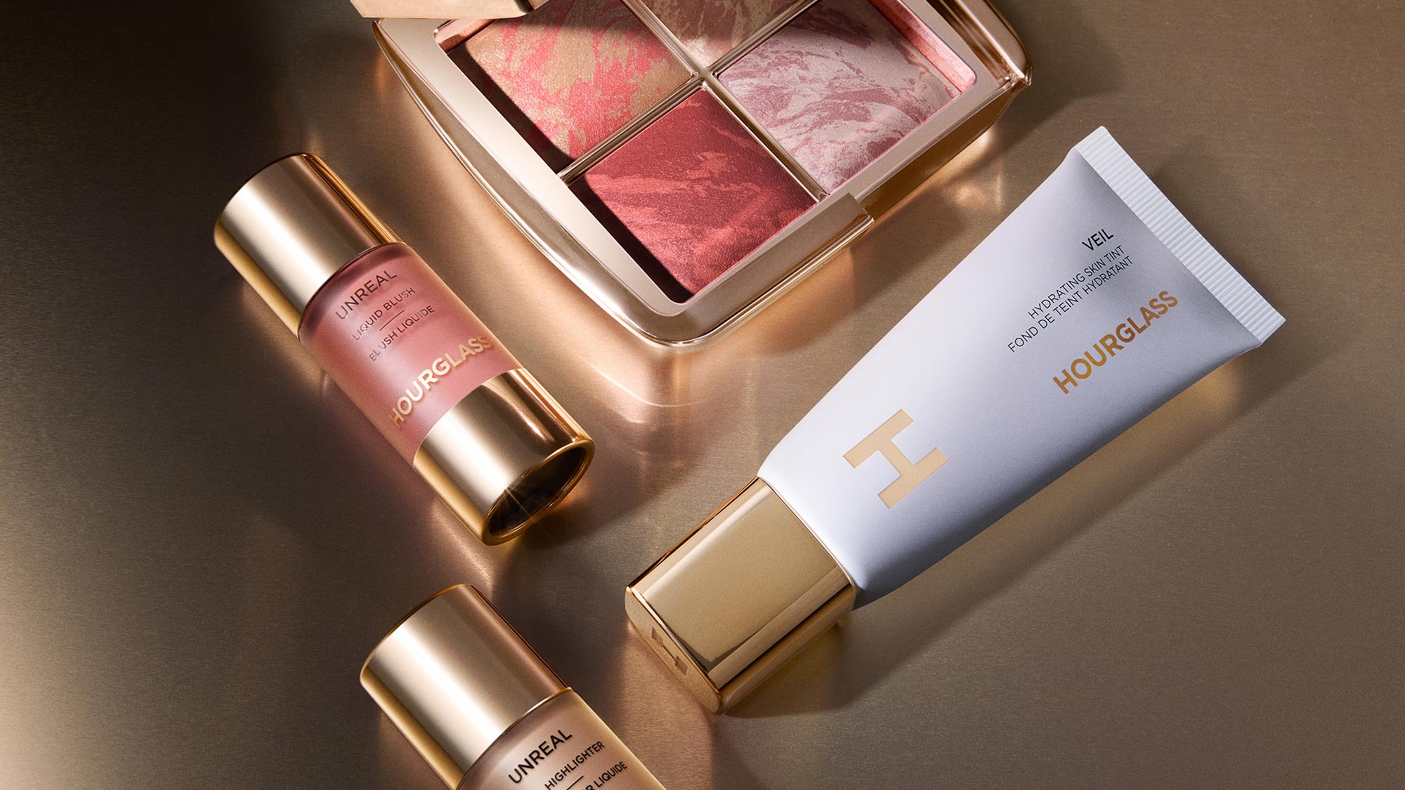 Hourglass liquid highlighters, multi-shade palette and hydrating veil on gold-toned surface