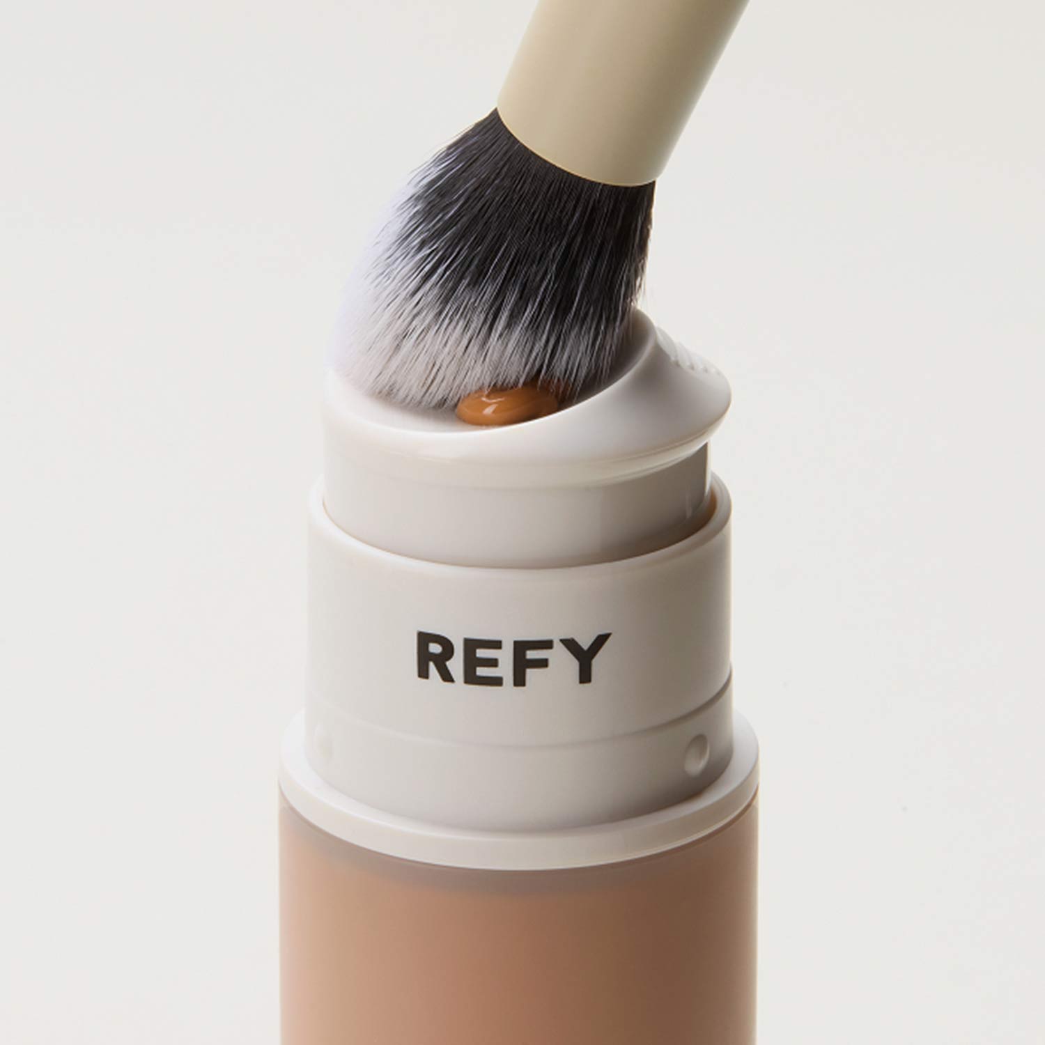 Multiple cylindrical makeup containers labeled 'REFY' in various skin tones.