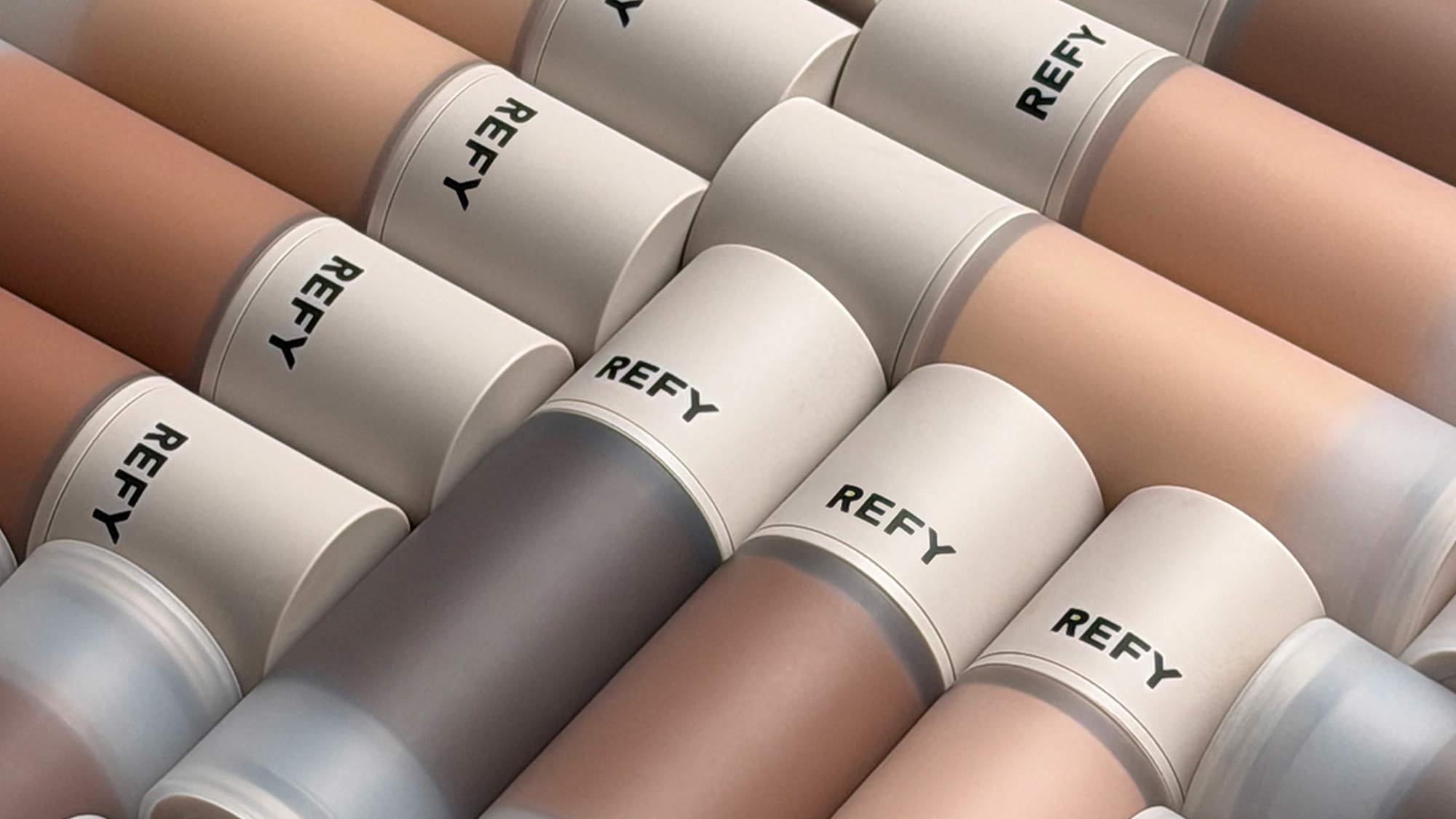 Multiple cylindrical makeup containers labeled 'REFY' in various skin tones.