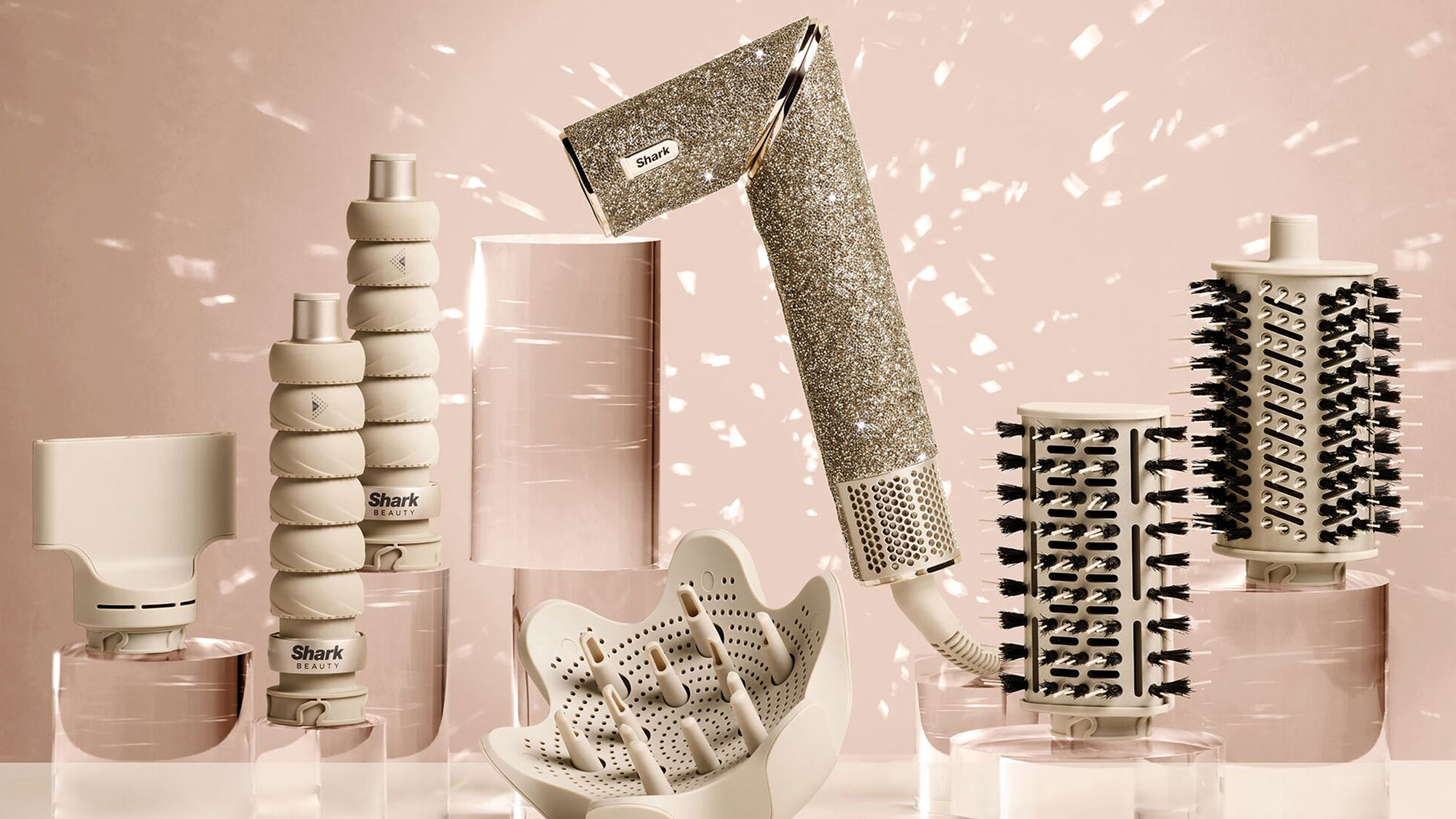 Shark Beauty collection of hair styling tools in cream and champagne colours, including hair dryer, brushes, and hot brush with sparkle background