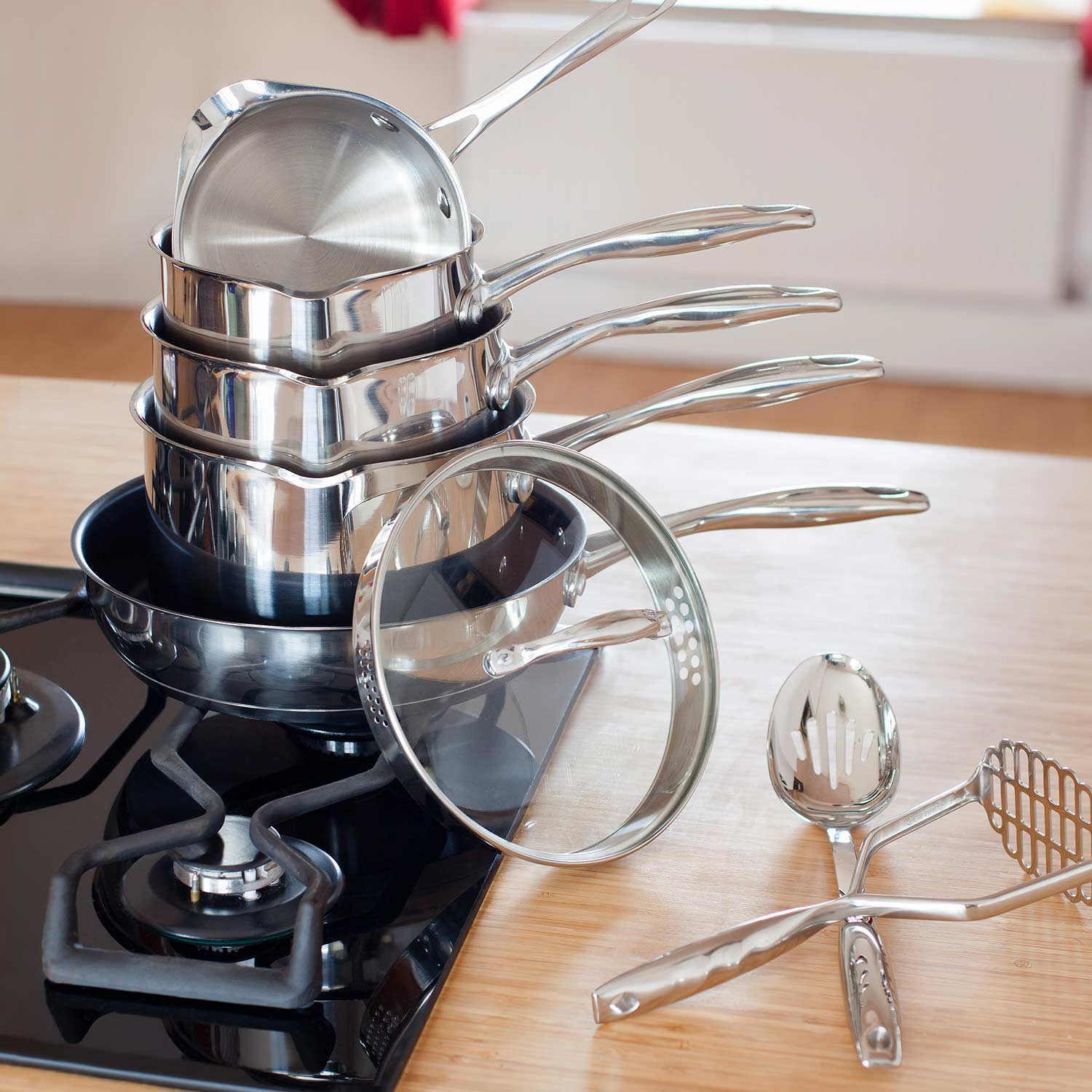 Collection of gleaming stainless steel pots and pans displayed in a bright kitchen
