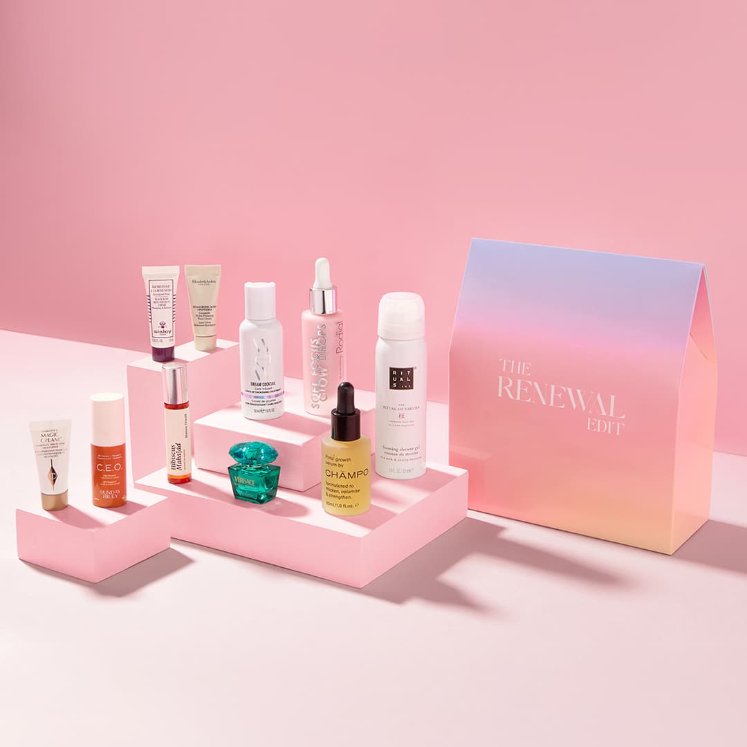 A collection of beauty and skincare products displayed on pink platforms against a soft pink background. The products include creams, serums, and sprays, positioned beside a colourful, gradient box labelled 'THE RENEWAL EDIT.'