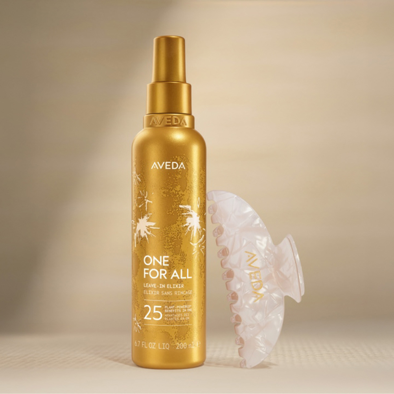 Aveda One For All leave-in elixir spray in gold bottle with decorative hair accessory