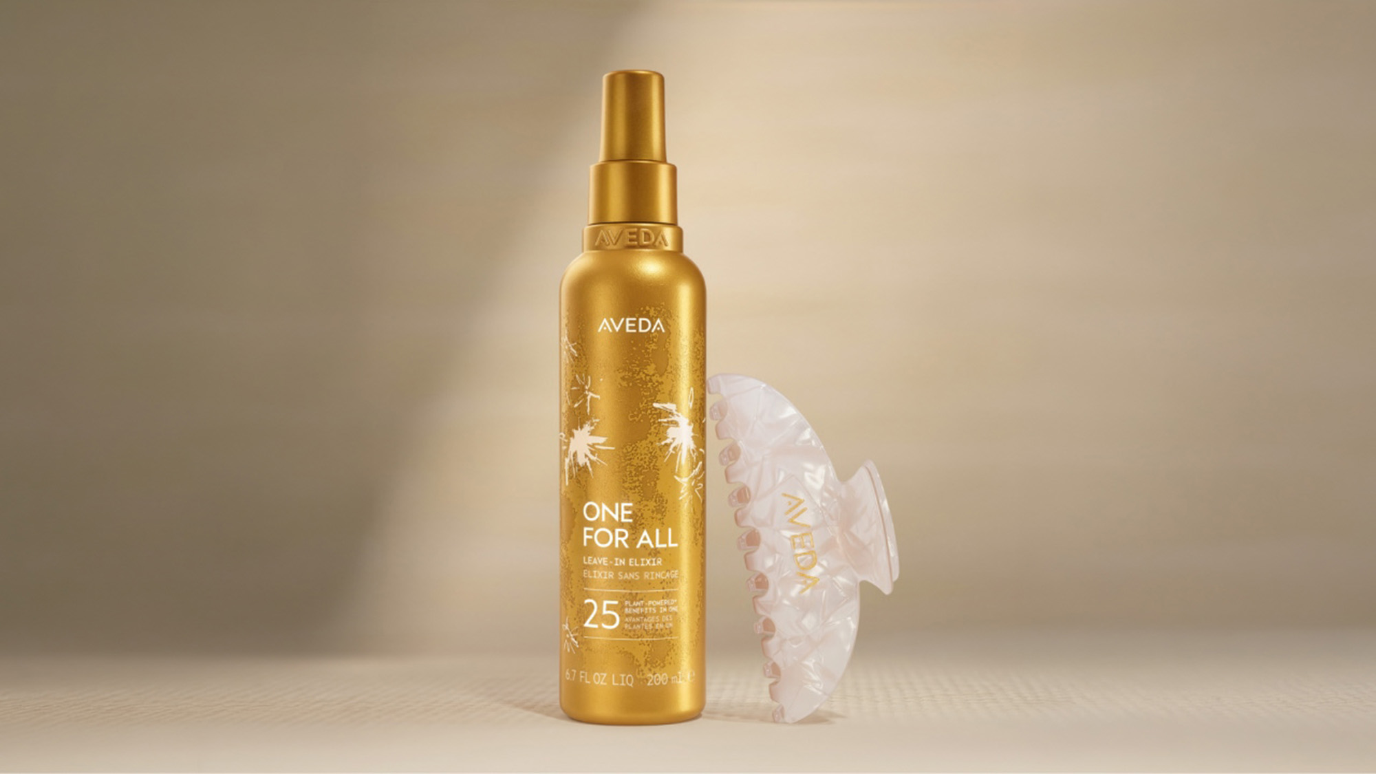 Aveda One For All leave-in elixir spray in gold bottle with decorative hair accessory