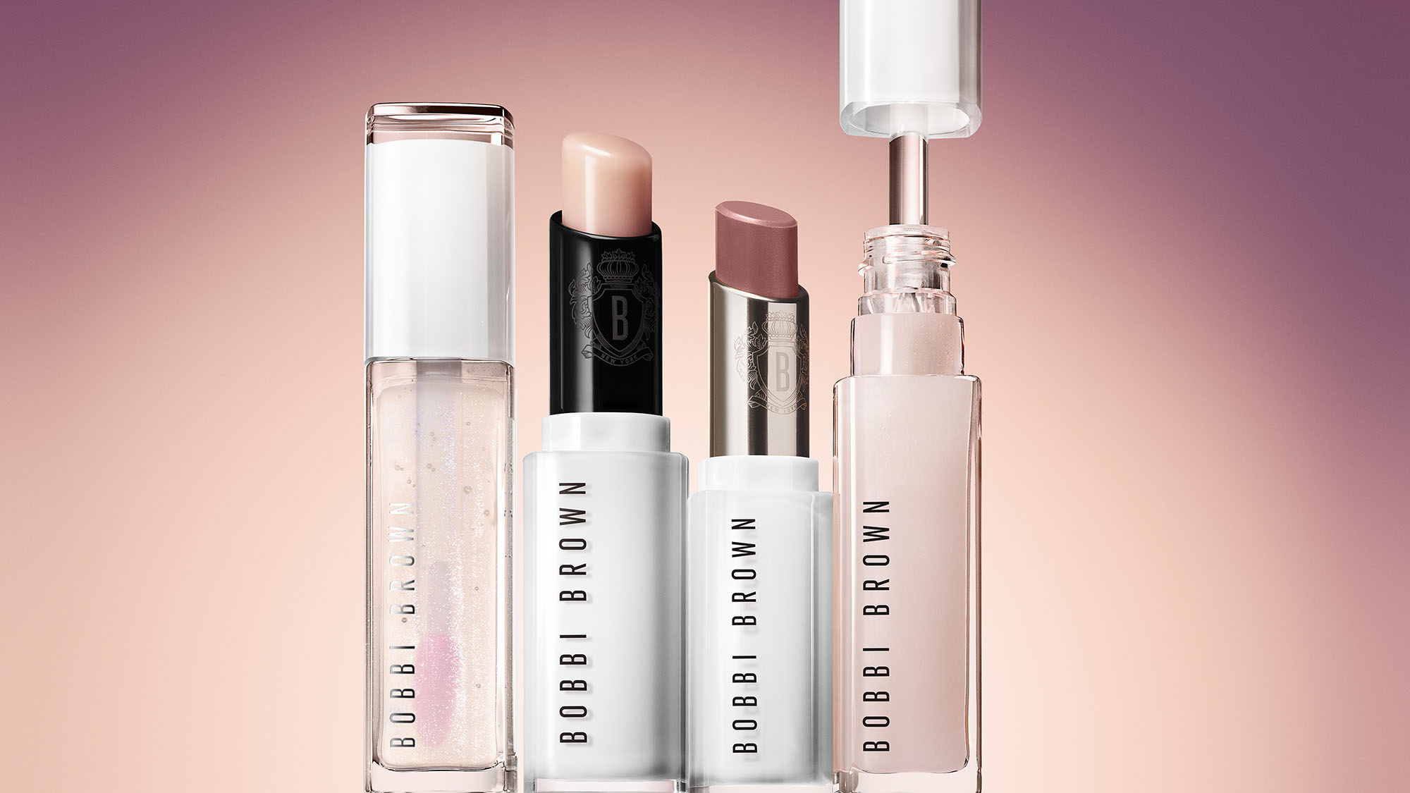 Four Bobbi Brown lip products in a gradient pink background.