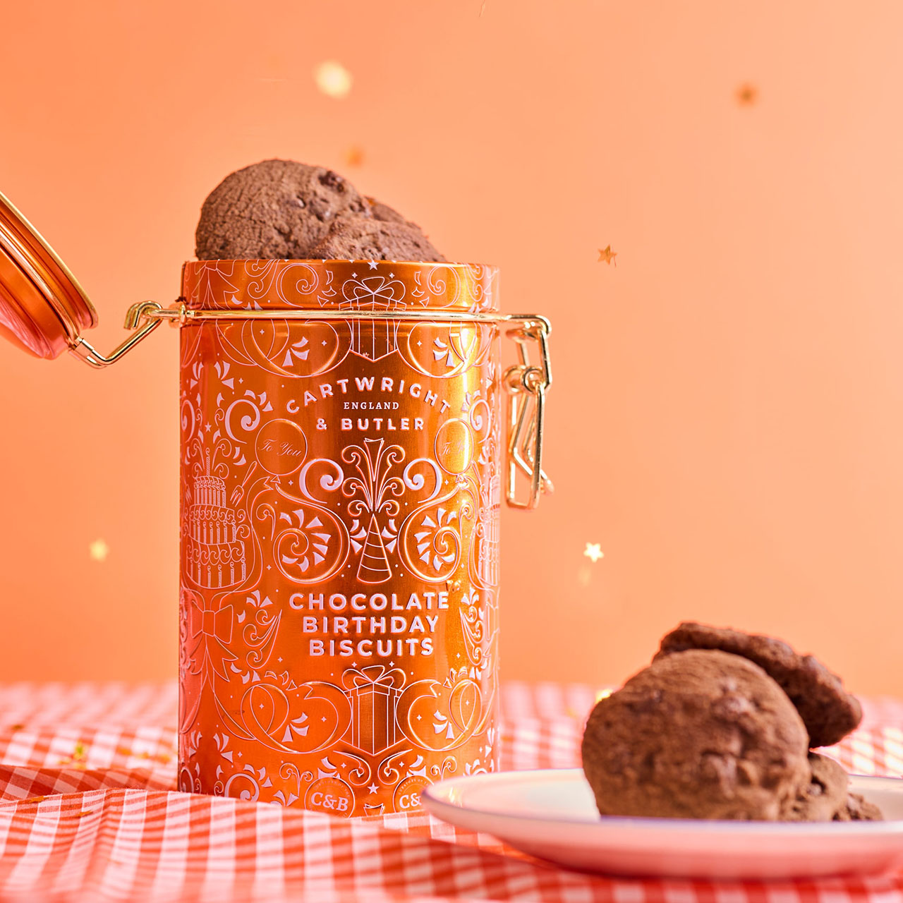 Cartwright & Butler chocolate birthday biscuits in orange decorative tin with chocolate biscuits displayed